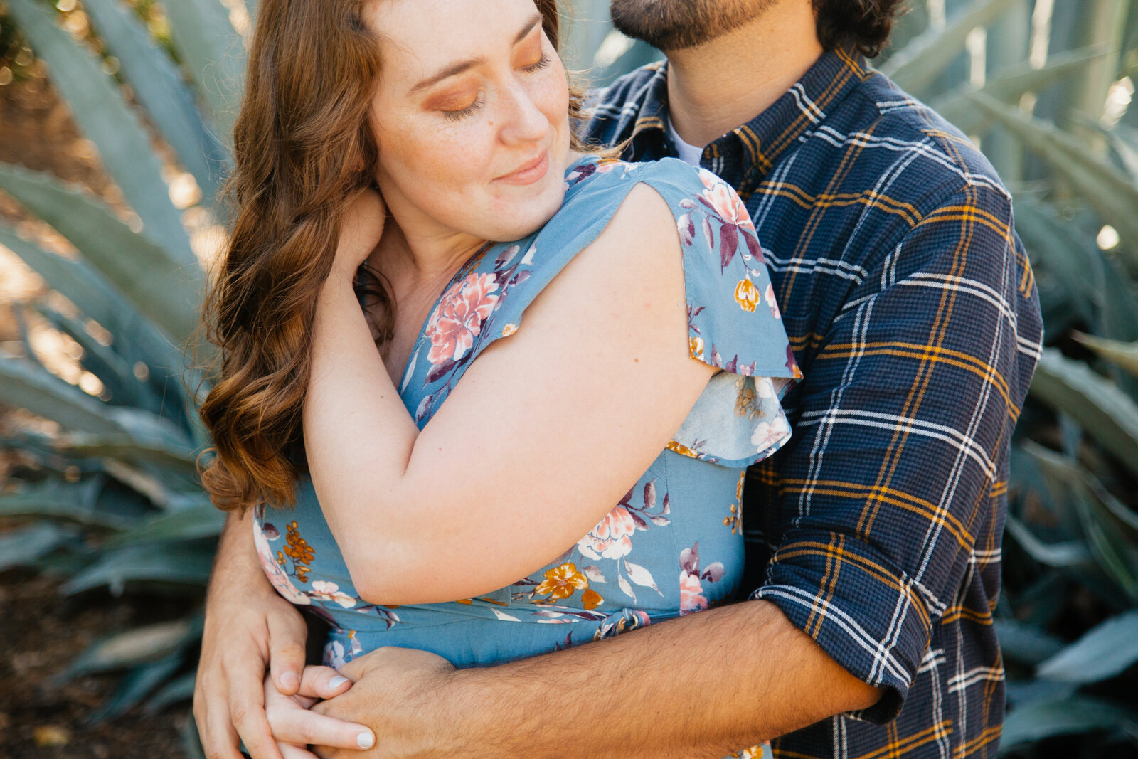 An engaged couple poses for photos in a garden in Los Angeles, Ca.