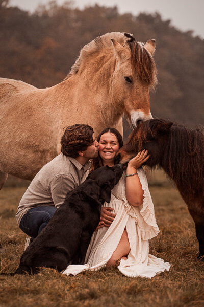 Een stralende aanstaande moeder poseert met haar paard in een serene, natuurlijke setting, die de bijzondere band tussen hen en de verwachting van nieuw leven vastlegt