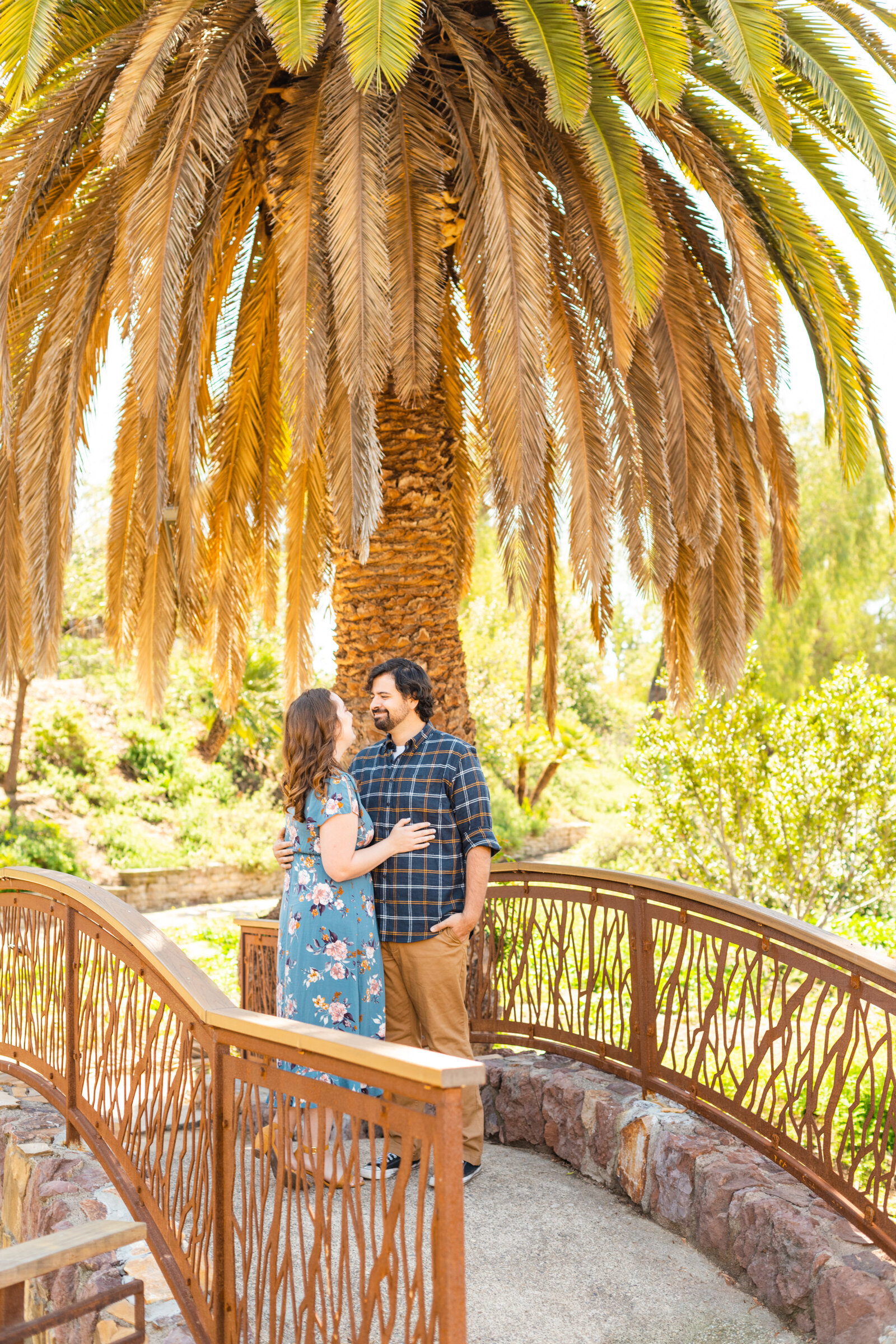 An engaged couple poses for photos in a garden in Los Angeles, Ca.