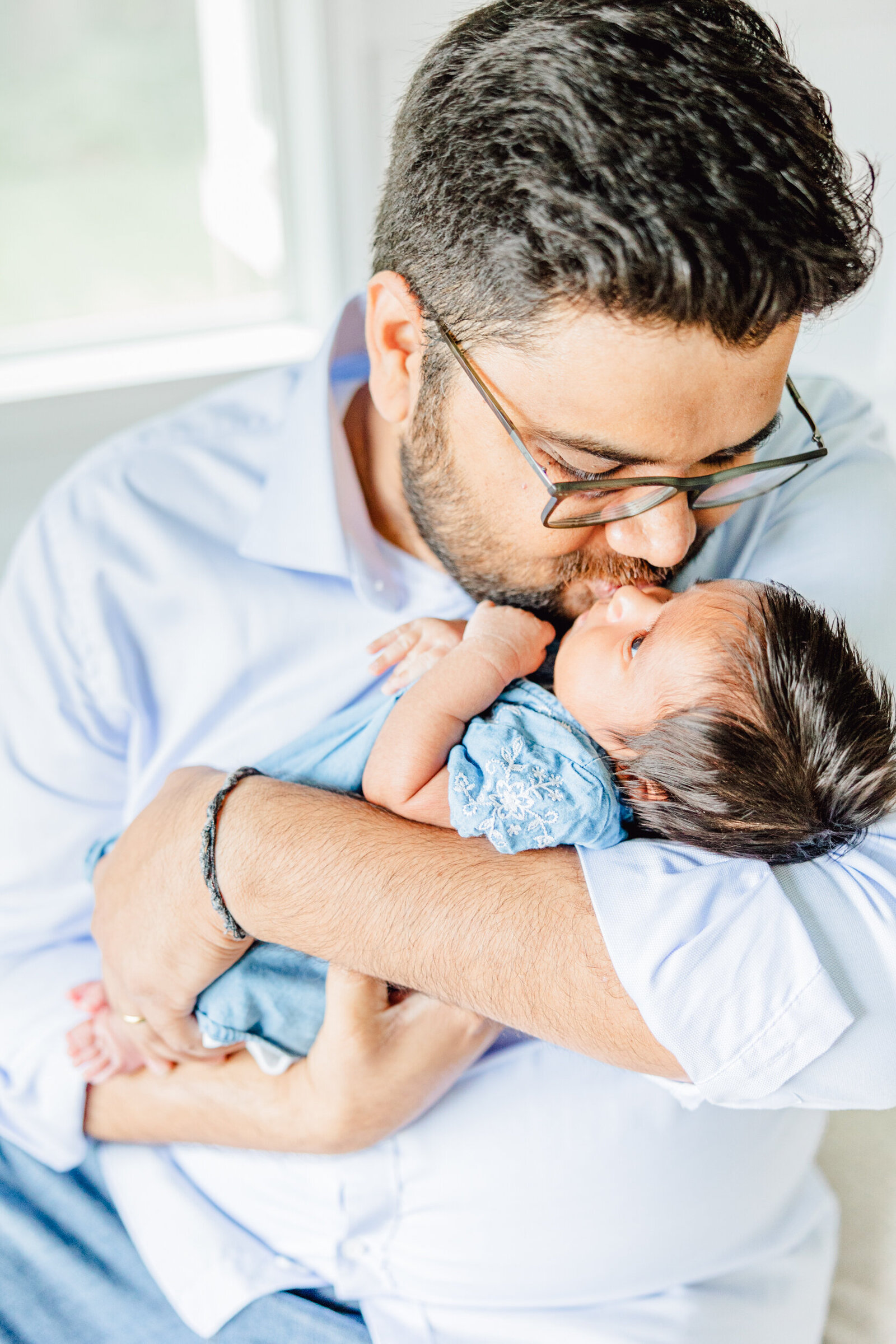 Dad kisses his newborn daughter