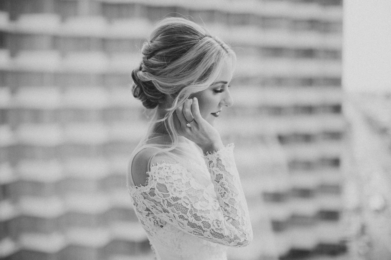 blonde woman wearing lace bridal gown with hair in classic updo