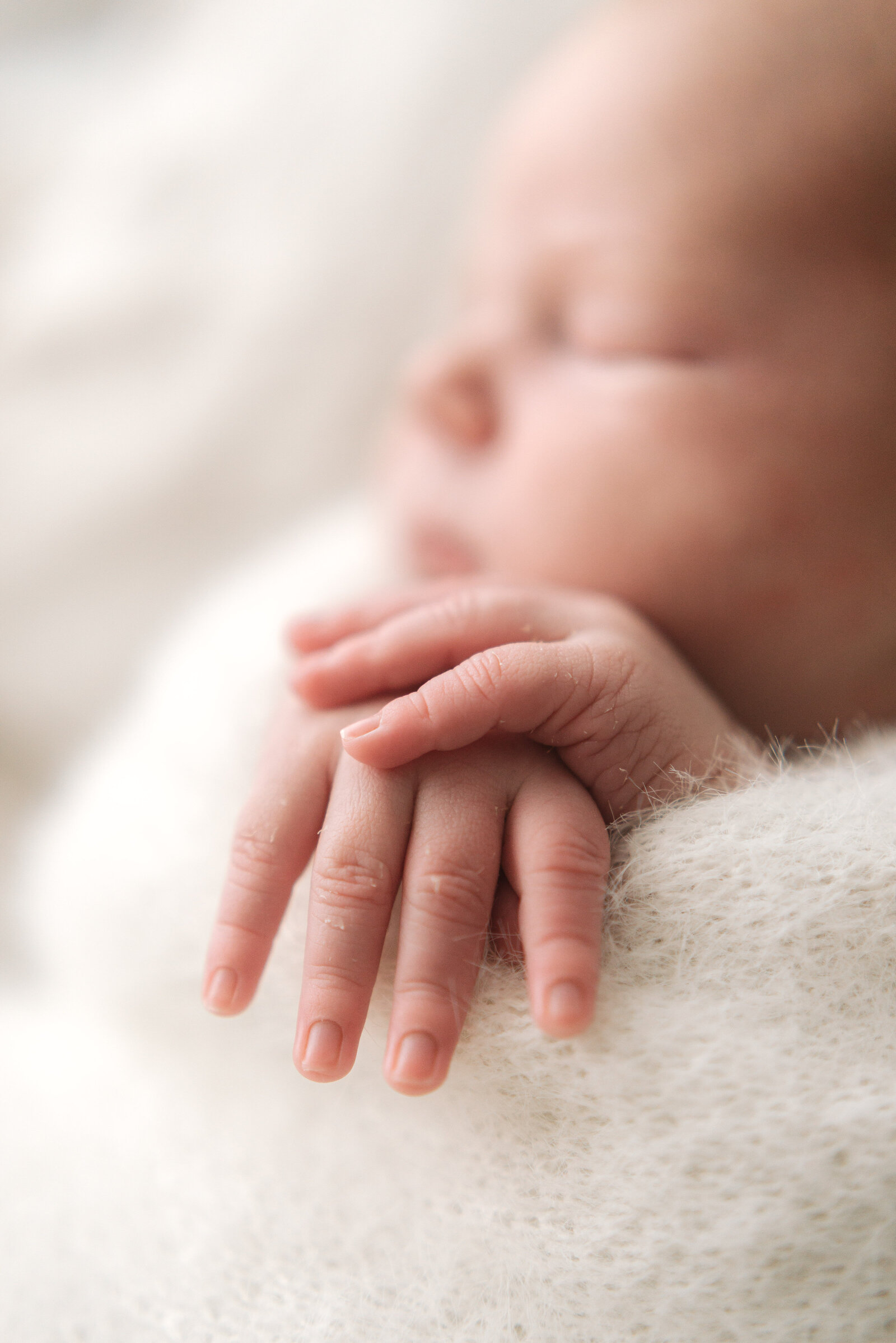 Close up of baby boys hands touching whilst on a newborn photoshoot in billingshurst