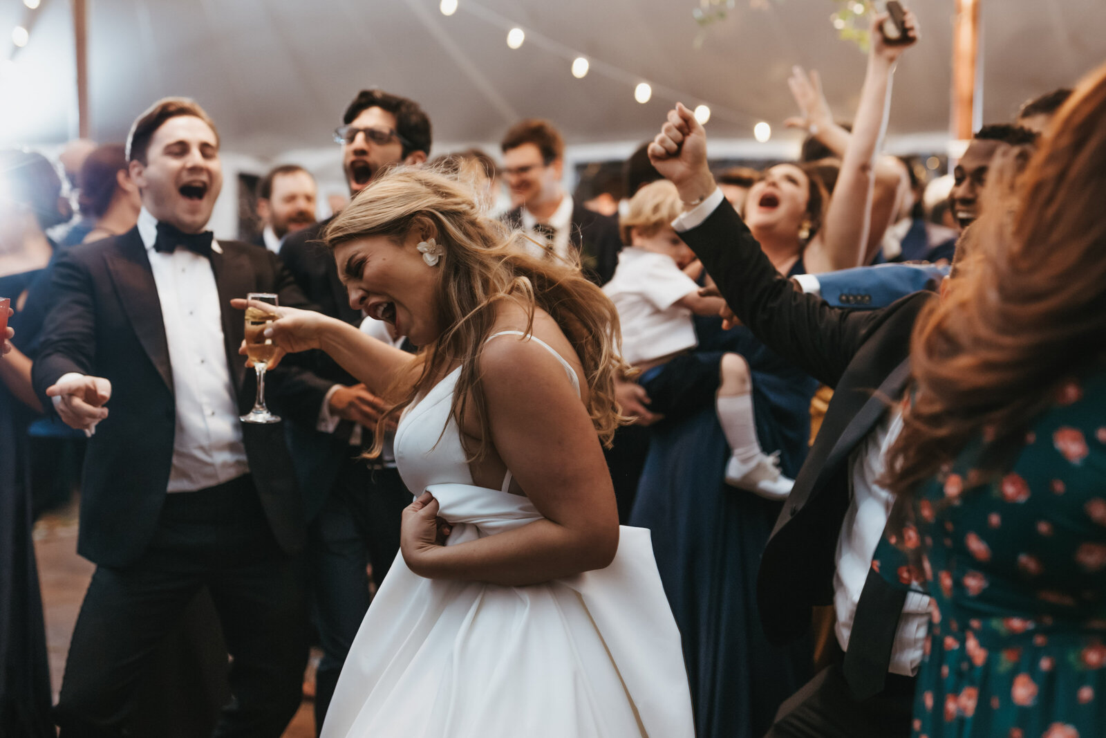 A bride dances with her friends during a wedding reception