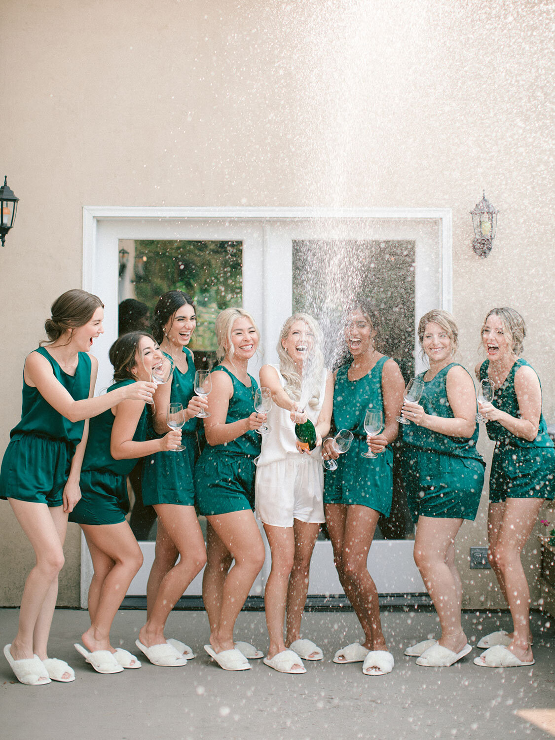 Bridal party popping champagne