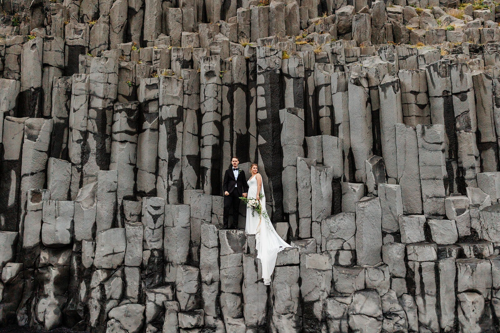 Elpoement Couple standing in a Reynisdrangar rock formation