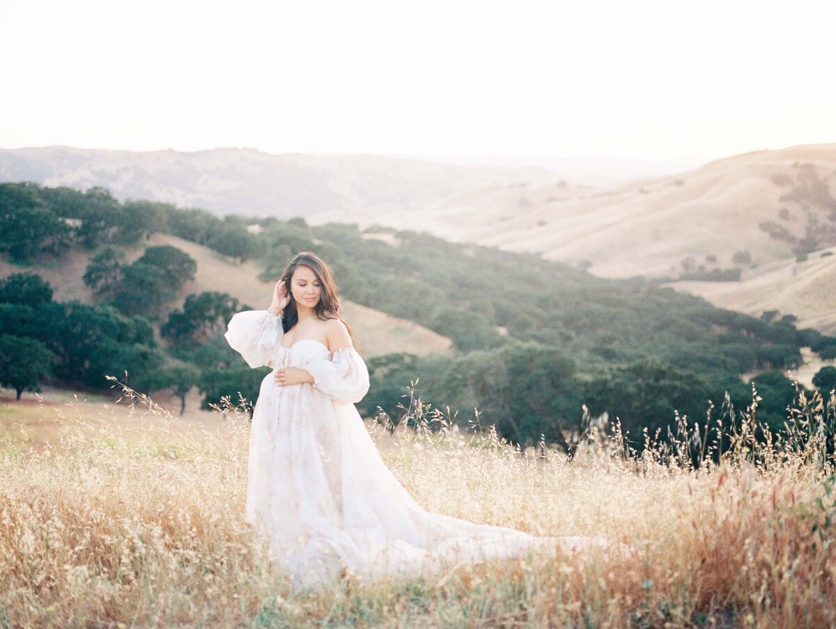 Golden hour maternity session by the water, capturing the expectant mother in a romantic, windswept dress, by maternity photographer in san francisco, Laurel Smith.