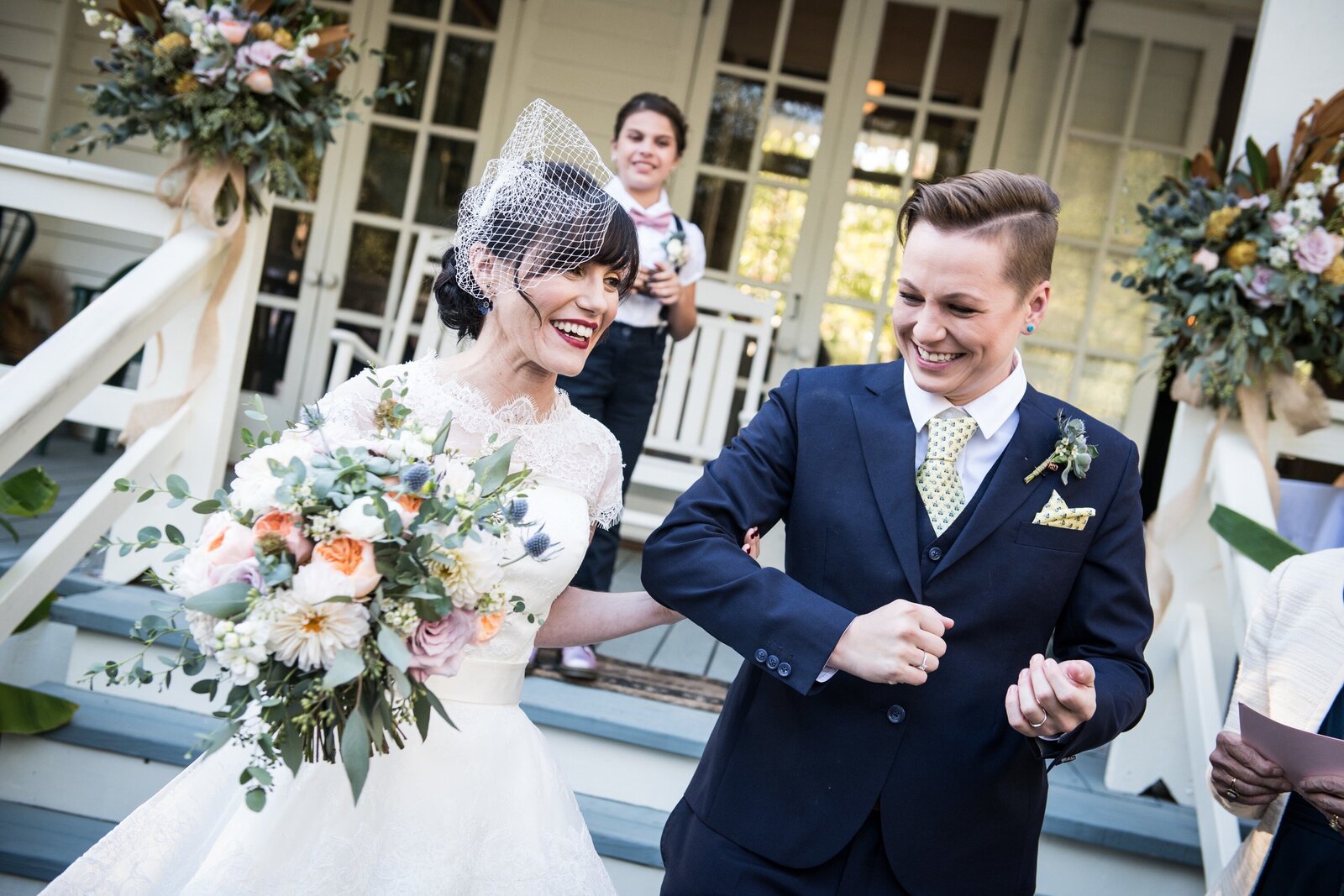 Two brides walking out at end of ceremony in Mandeville, Louisiana