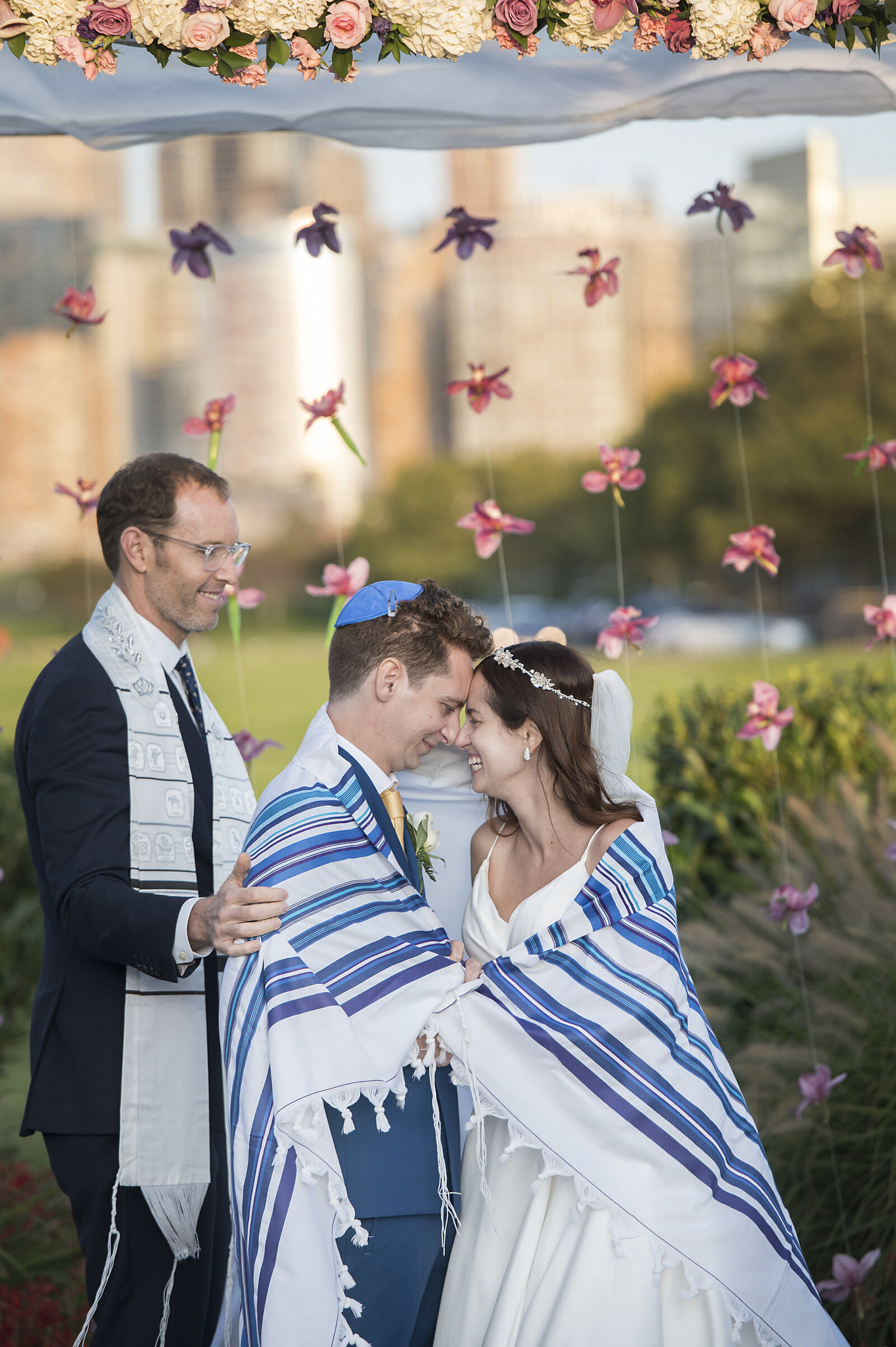 A Jewish couple standing forehead to forehead during their wedding ceremony 