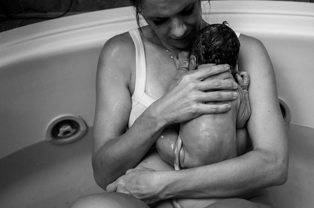 mother holds baby to her chest after waterbirth