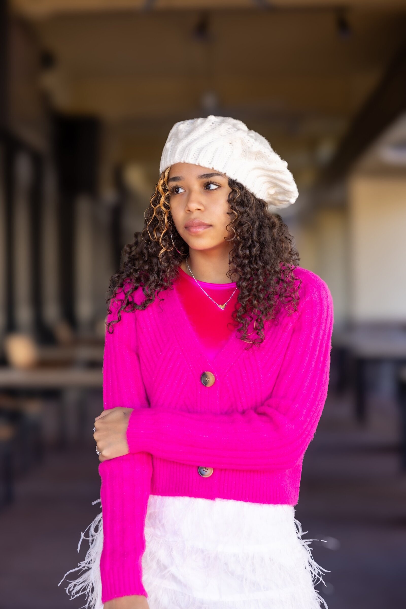 a teenage girl wearing a white beret and pink sweater