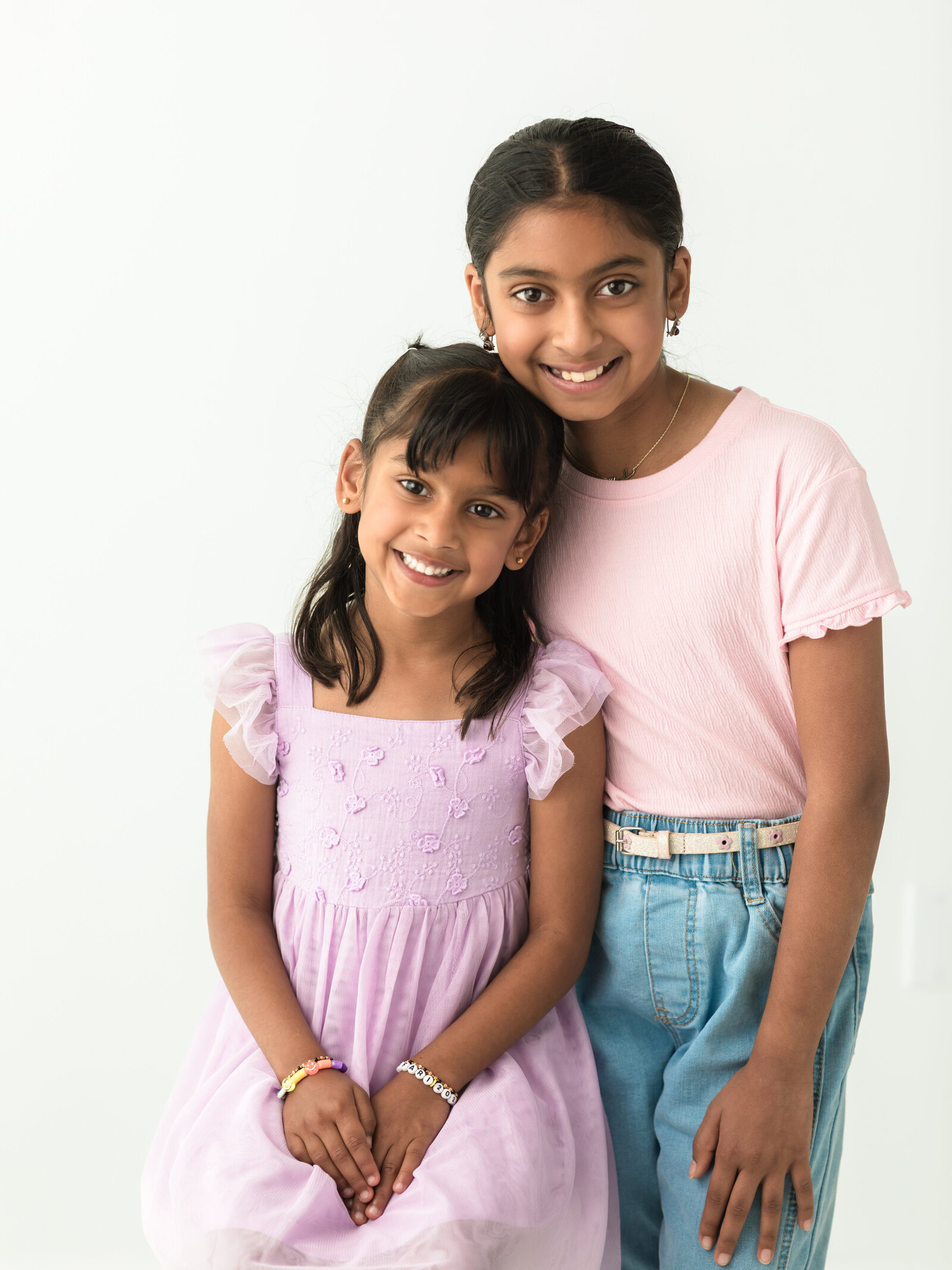 sisters in pink posing for studio portraits