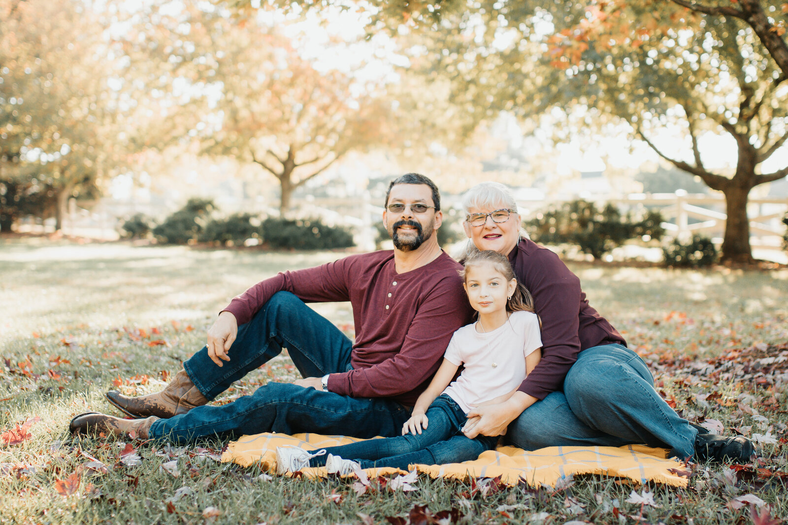 family of three sitting in a park in Colfax NC
