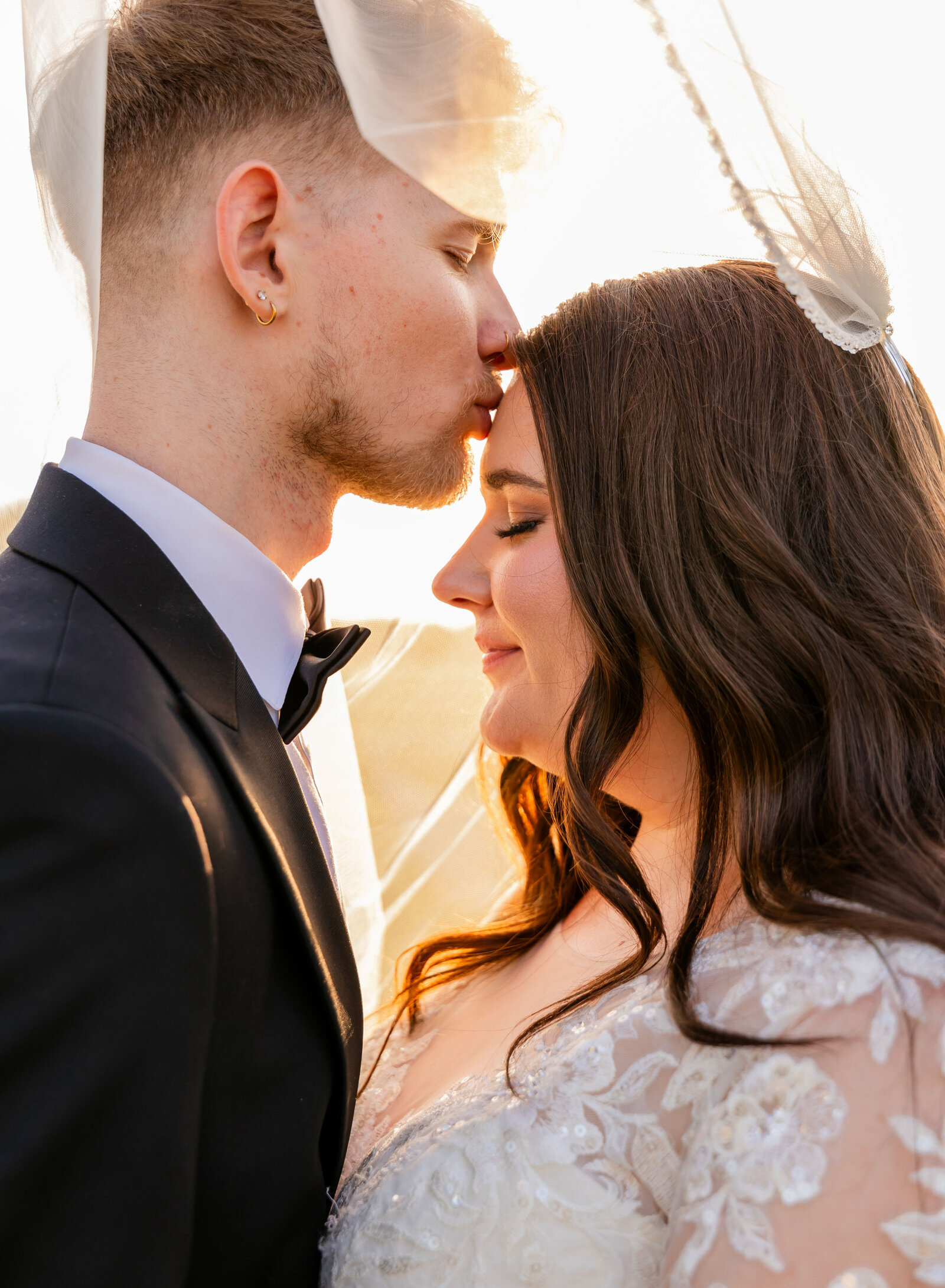 groom kissing bride's forehead