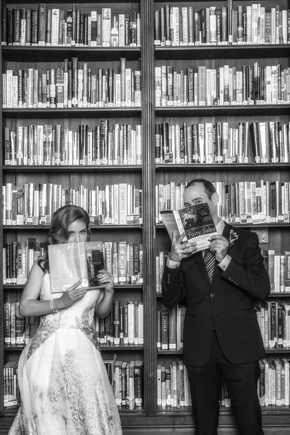 A bride and groom in a library reading fairy tales