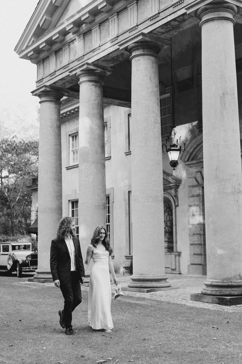 Bride and groom hold hands in front of Atlanta Swan House