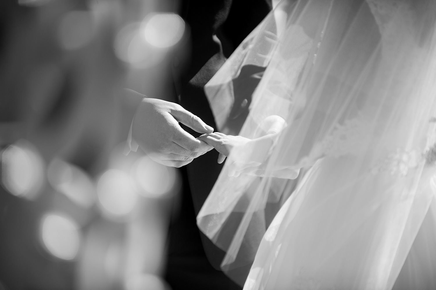 groom putting on brides wedding ring