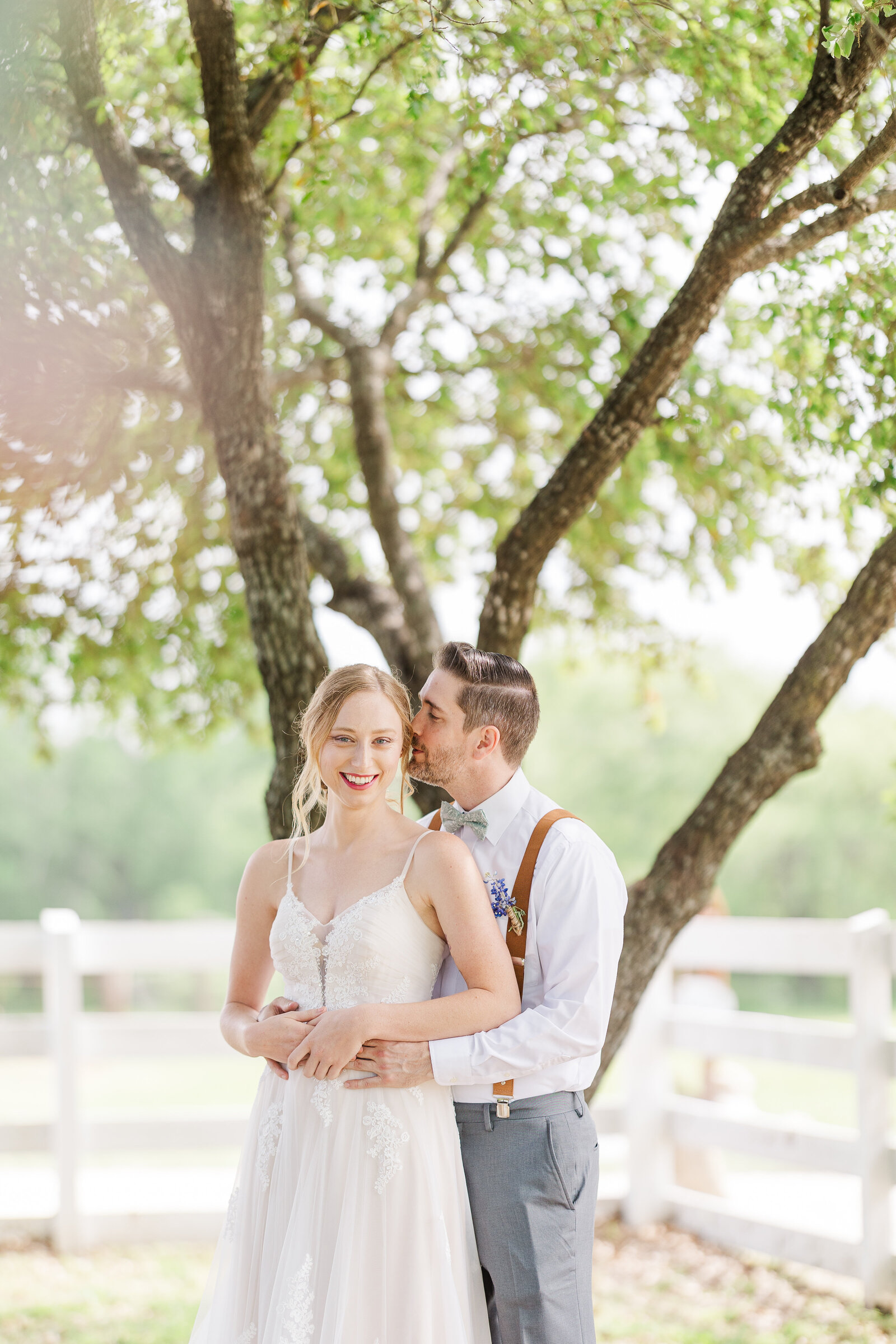 Groom-holding-bride-waist-kissing-forehead