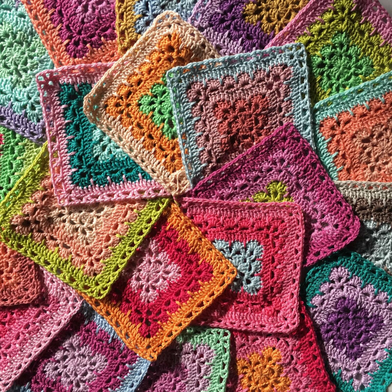 Pile of colorful hand crocheted squares.