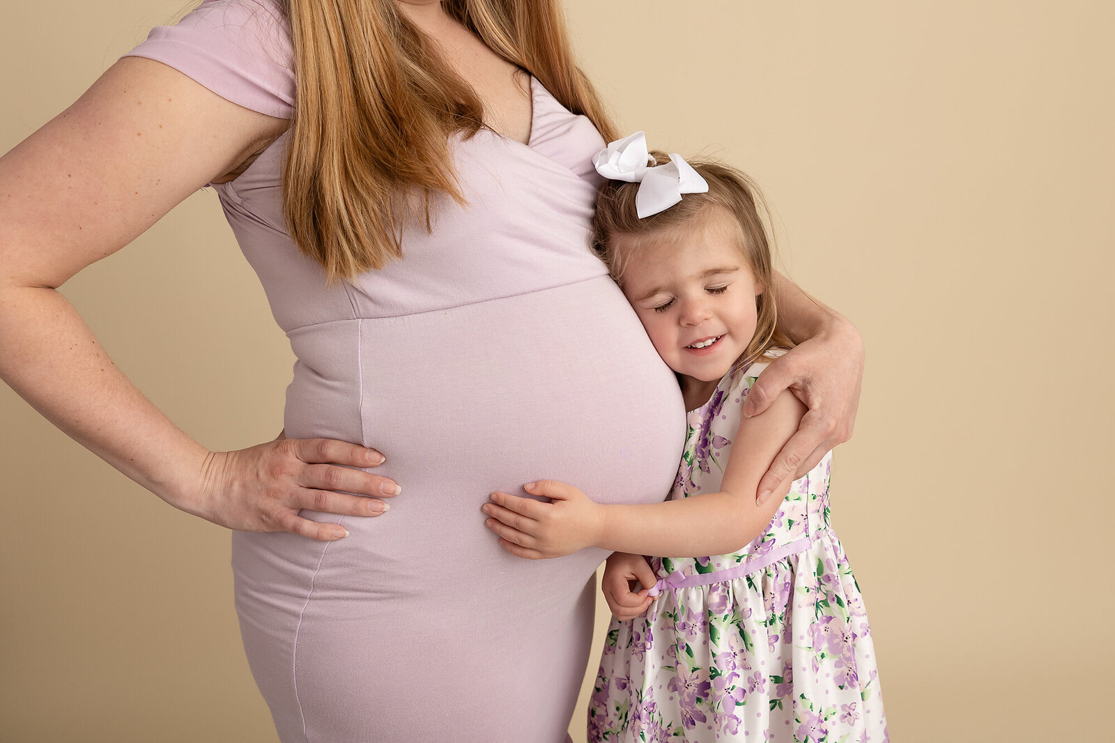 toddler cuddling moms pregnant belly by PHILADELPHIA MATERNITY PHOTOGRAPHER