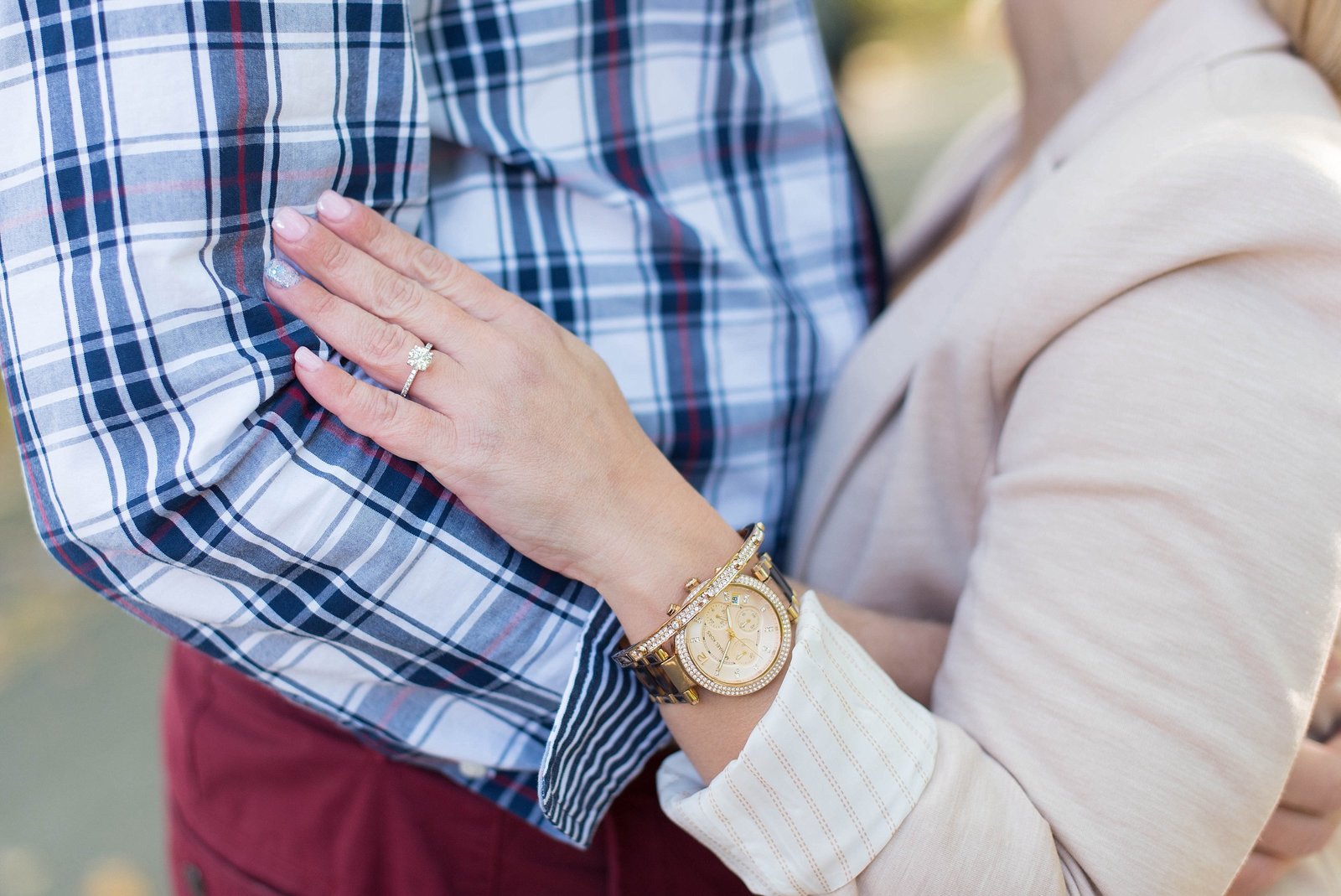 Detail shot of bride wearing silver engagement ring and gold bracelet and watch photo