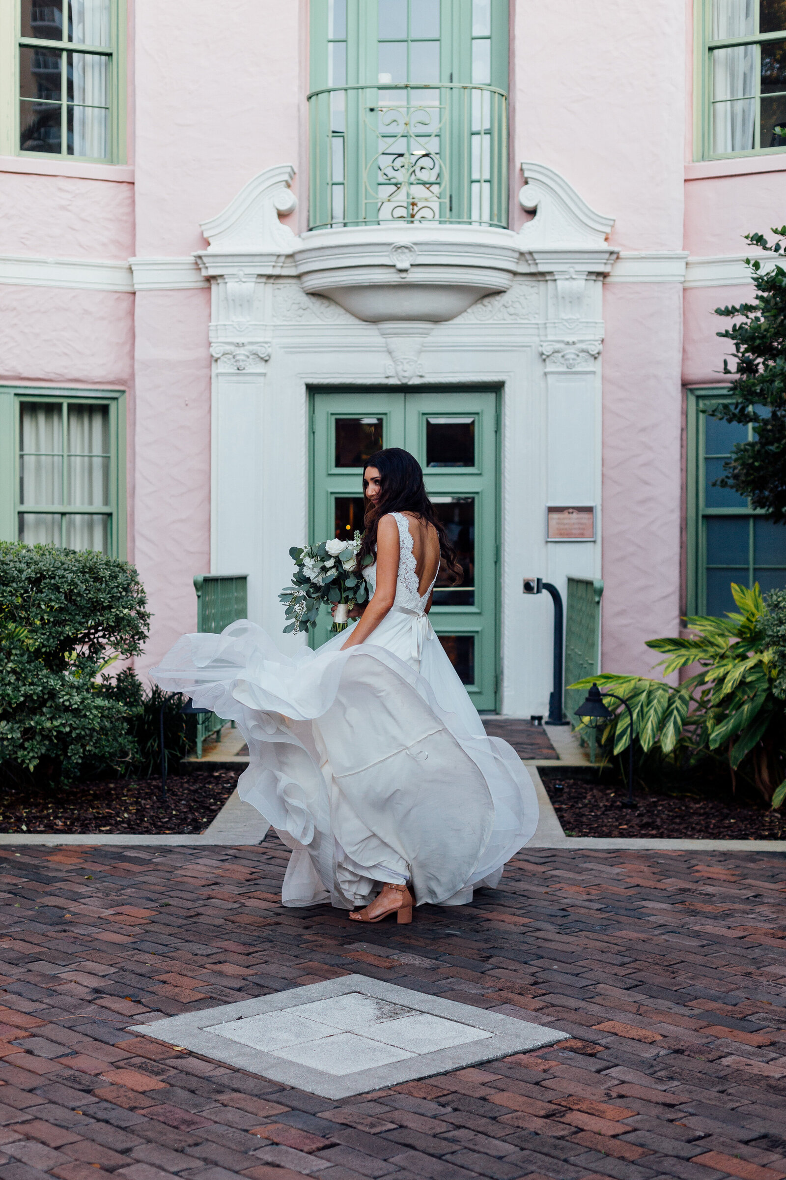 bride-walking-with-flowing-dress-into-pink-house-in-florida-photo-iris-and-urchin-ryley