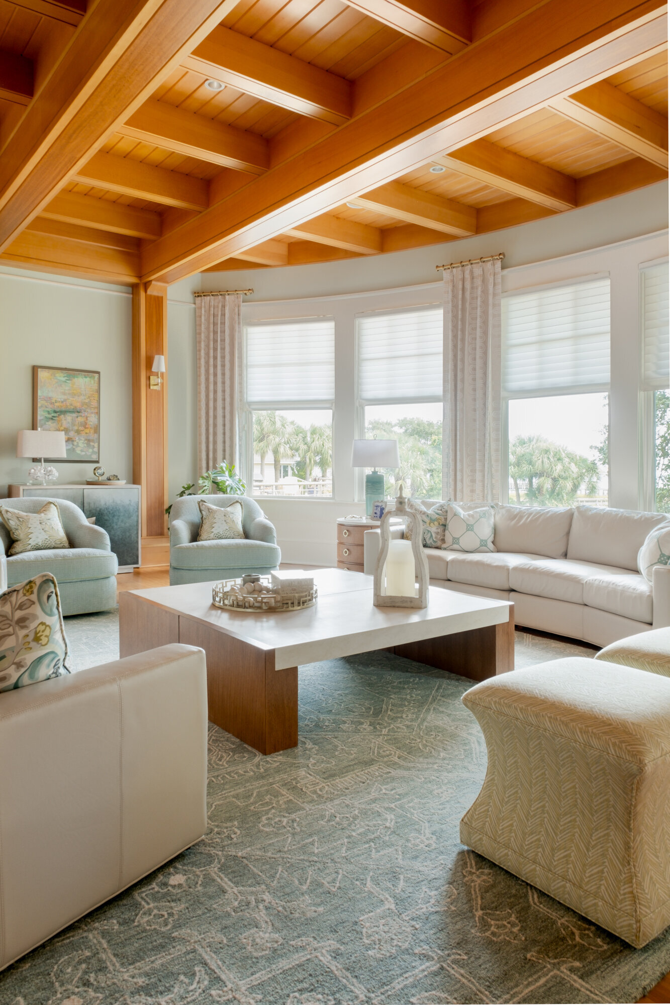 Living room remodel of a coastal home in Wilmington, NC, featuring serene, watery colors, updated flooring, and large windows framing stunning Intracoastal Waterway views."