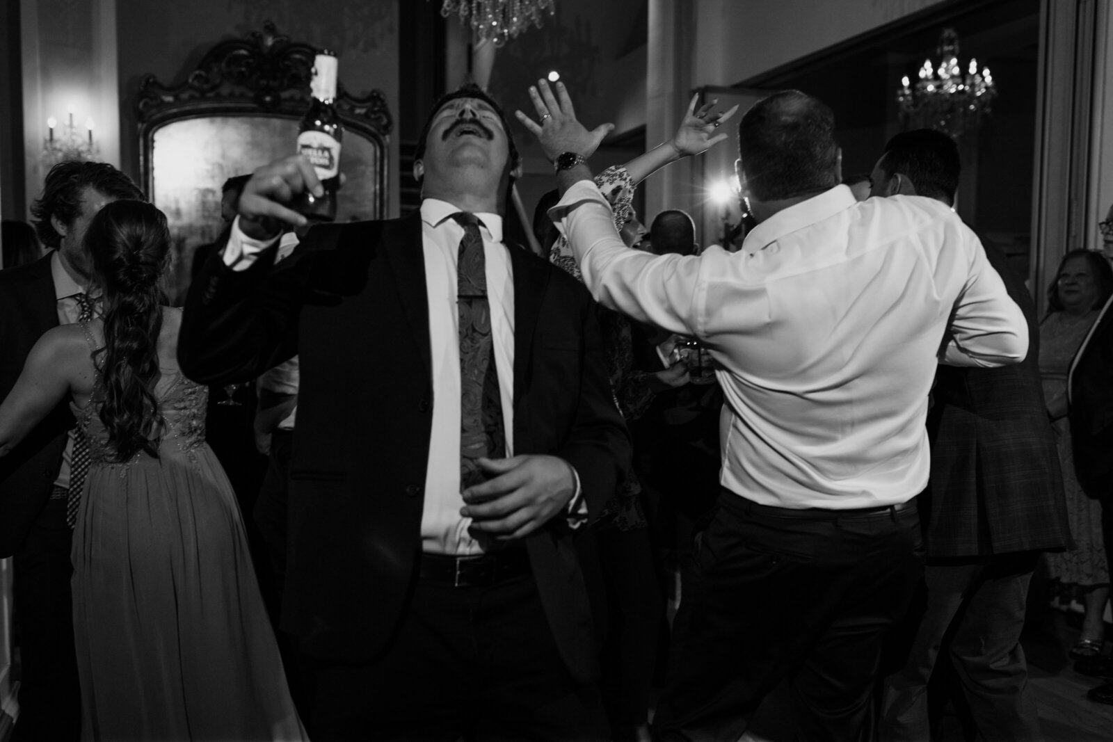 Guests dance while holding beer during a wedding reception