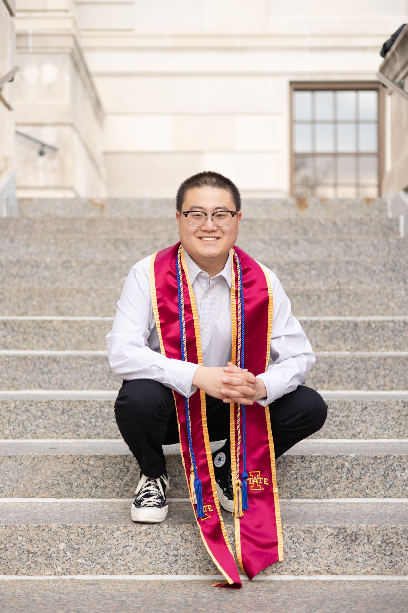 young man poses for college graduation photo at the Memorial Union