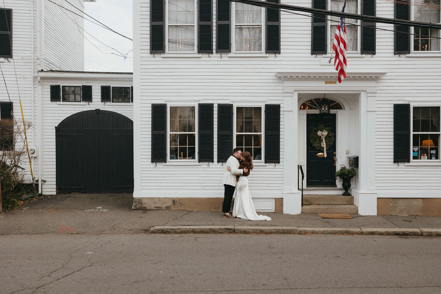 Bride and groom kissing in front of their modern wedding venue