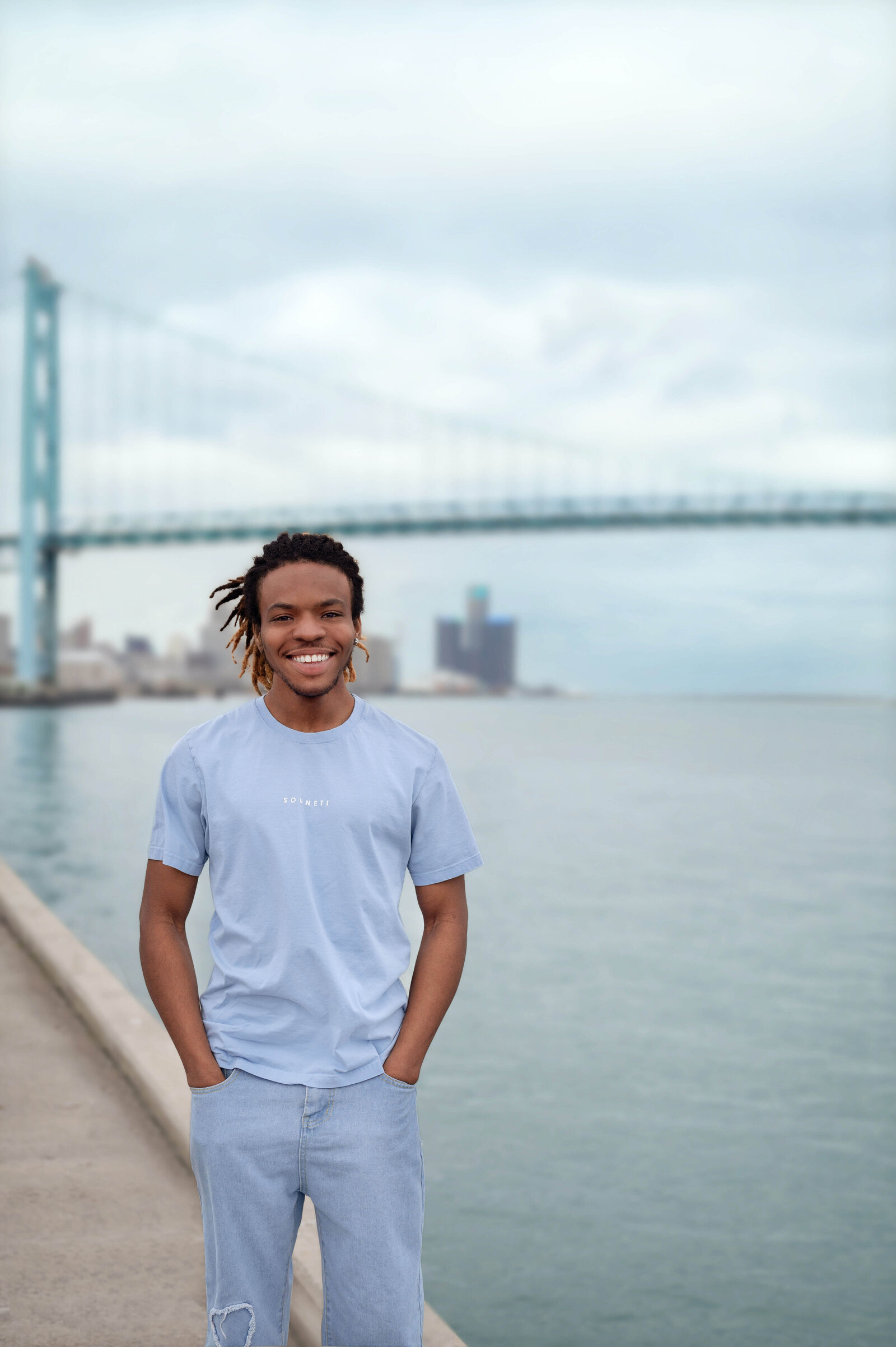 Senior guy standing in front of bridge and water