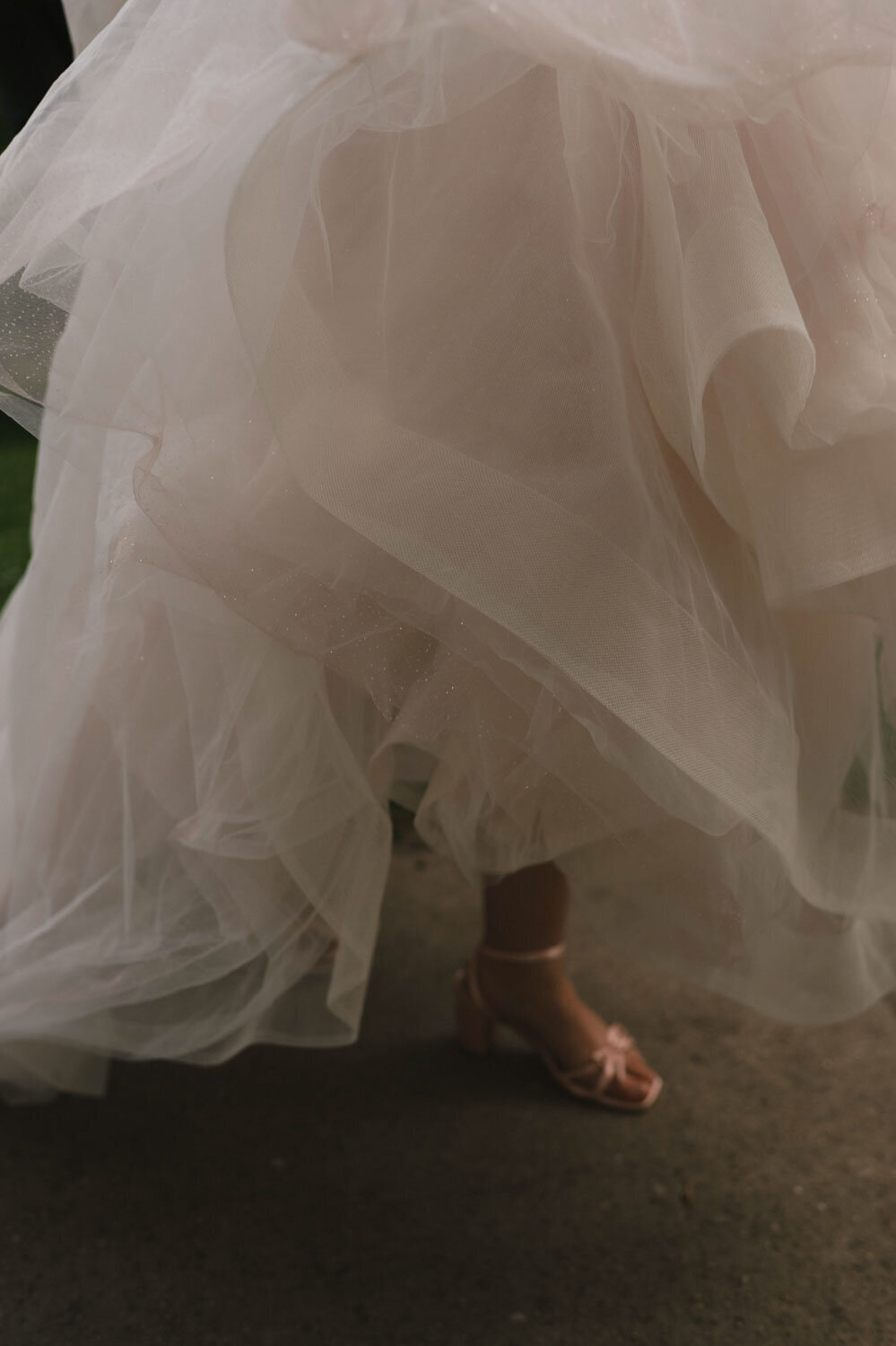 Close-up of layered tulle wedding gown and shoes