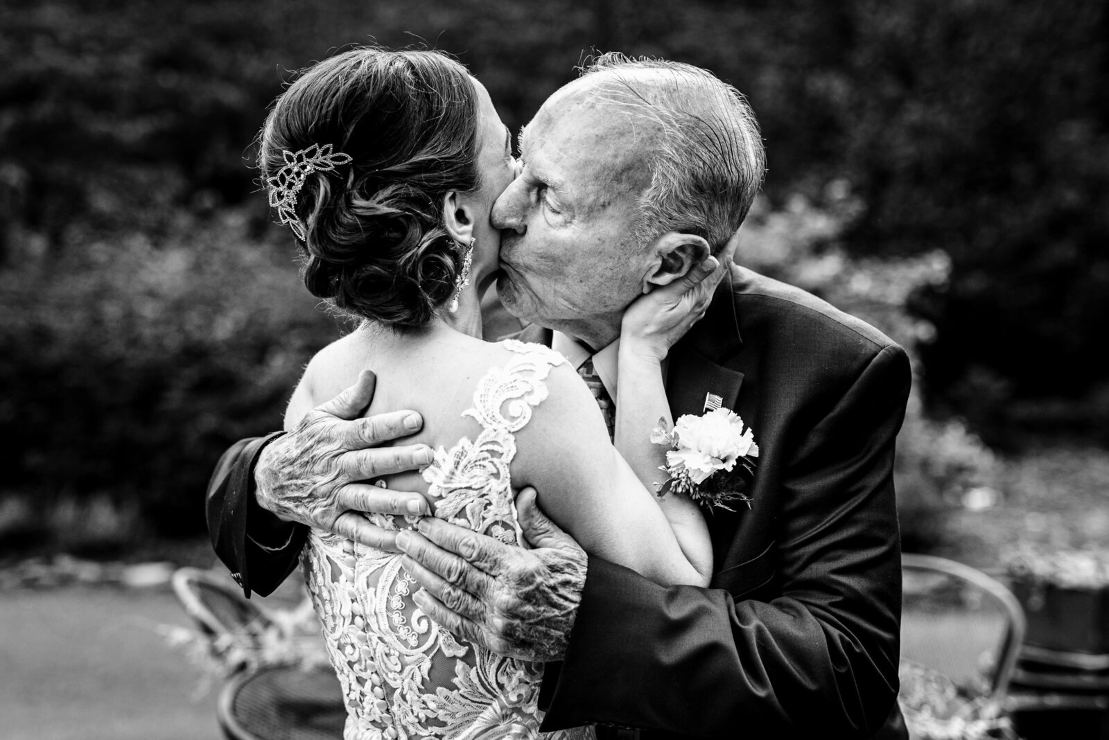 black and white photo of  a bride's  grandfather embracing her