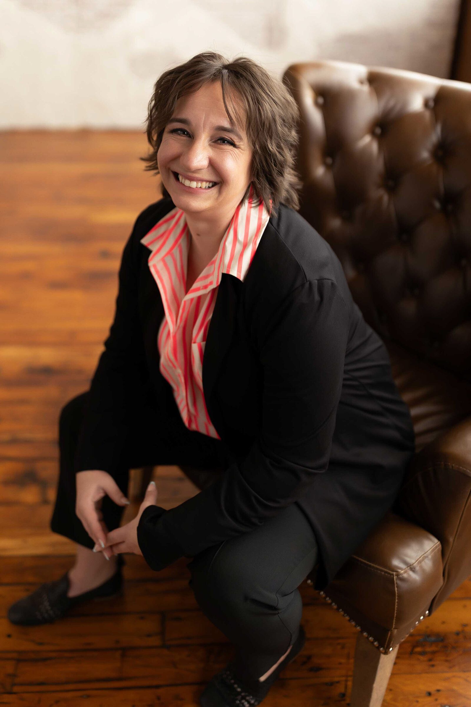 woman wearing a formal suite sitting on a couch