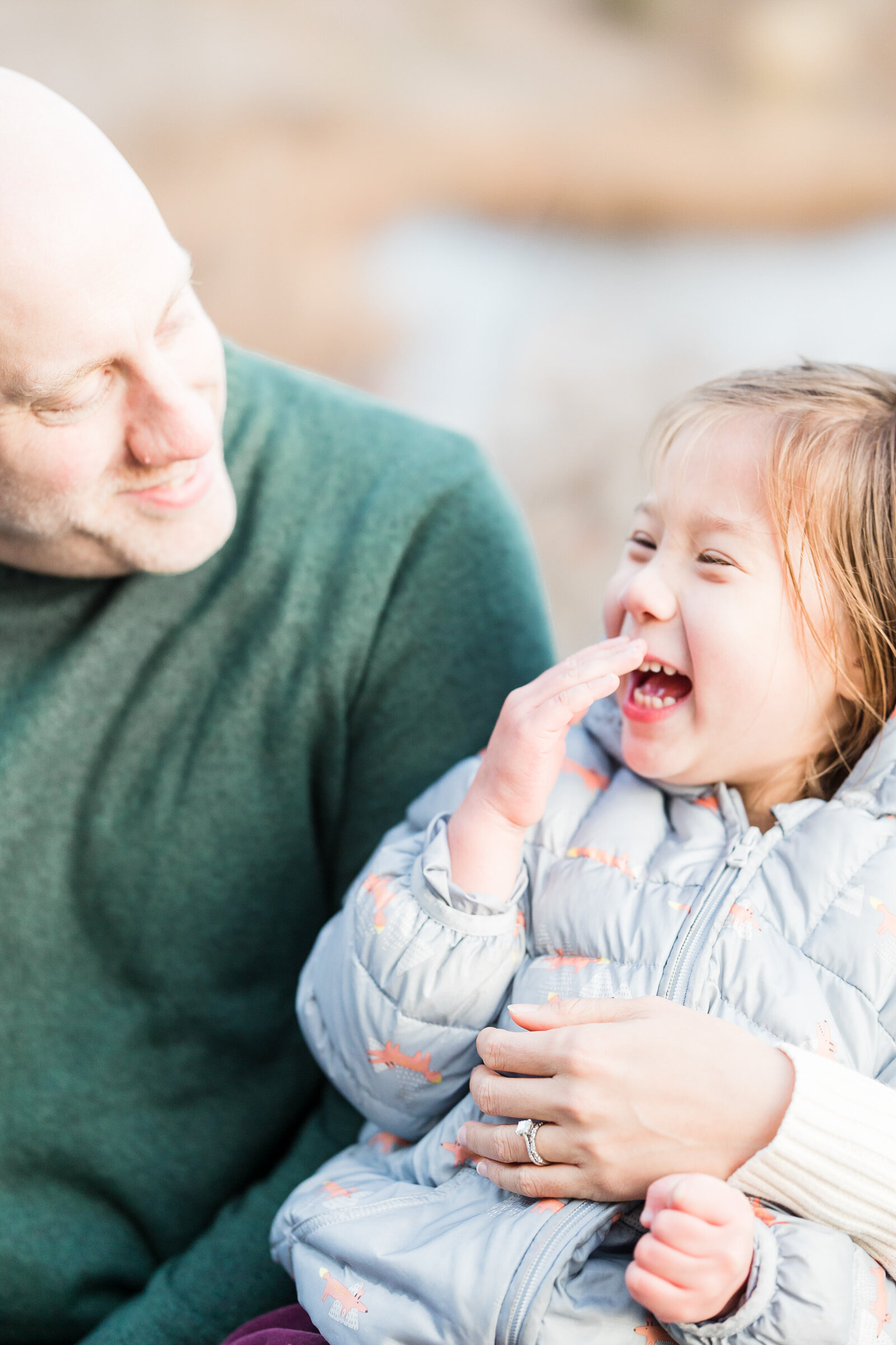 daughter laughing at father while covering her mouth