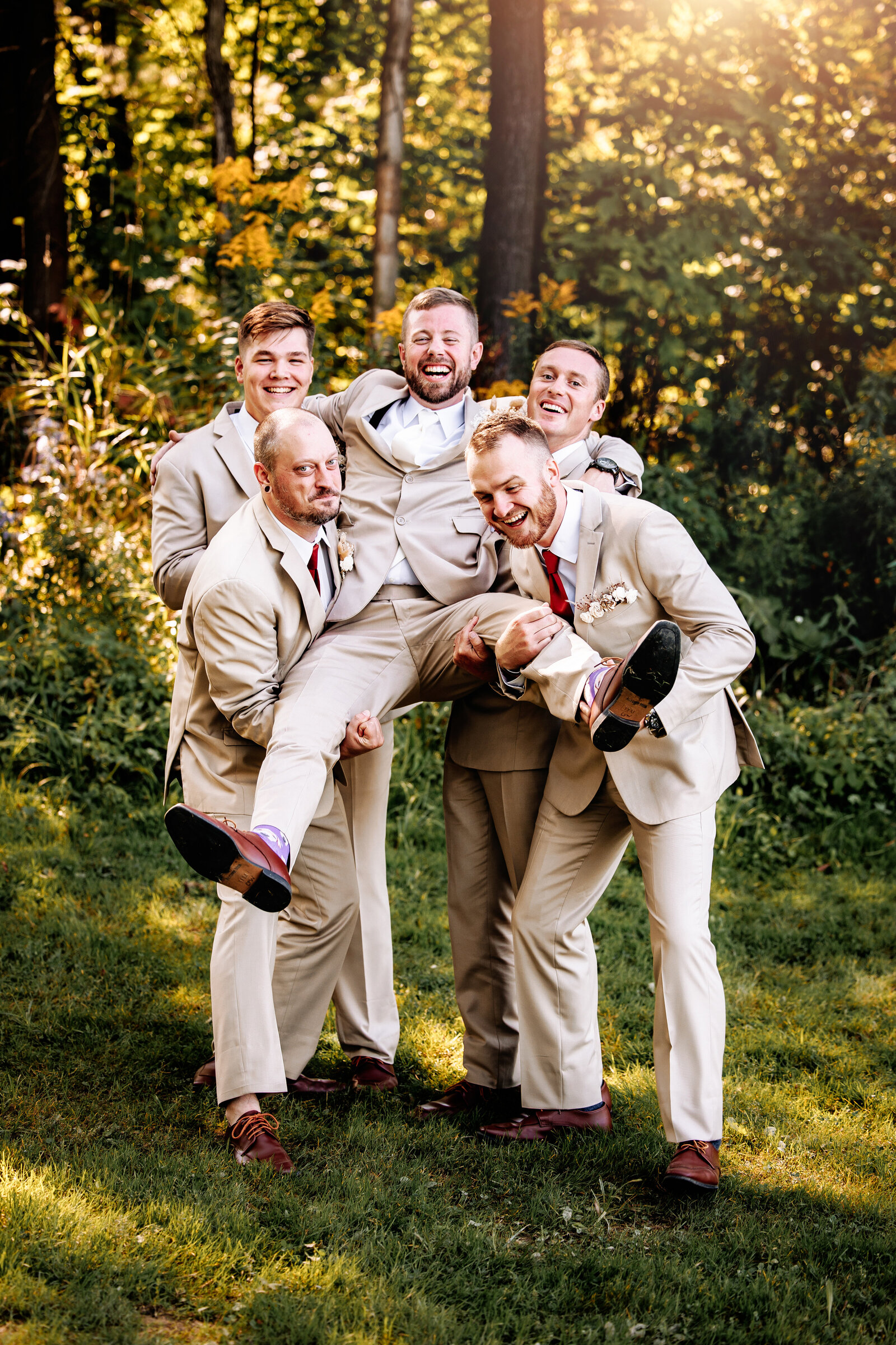 Groomsman hold groom up for a funny wedding portrait