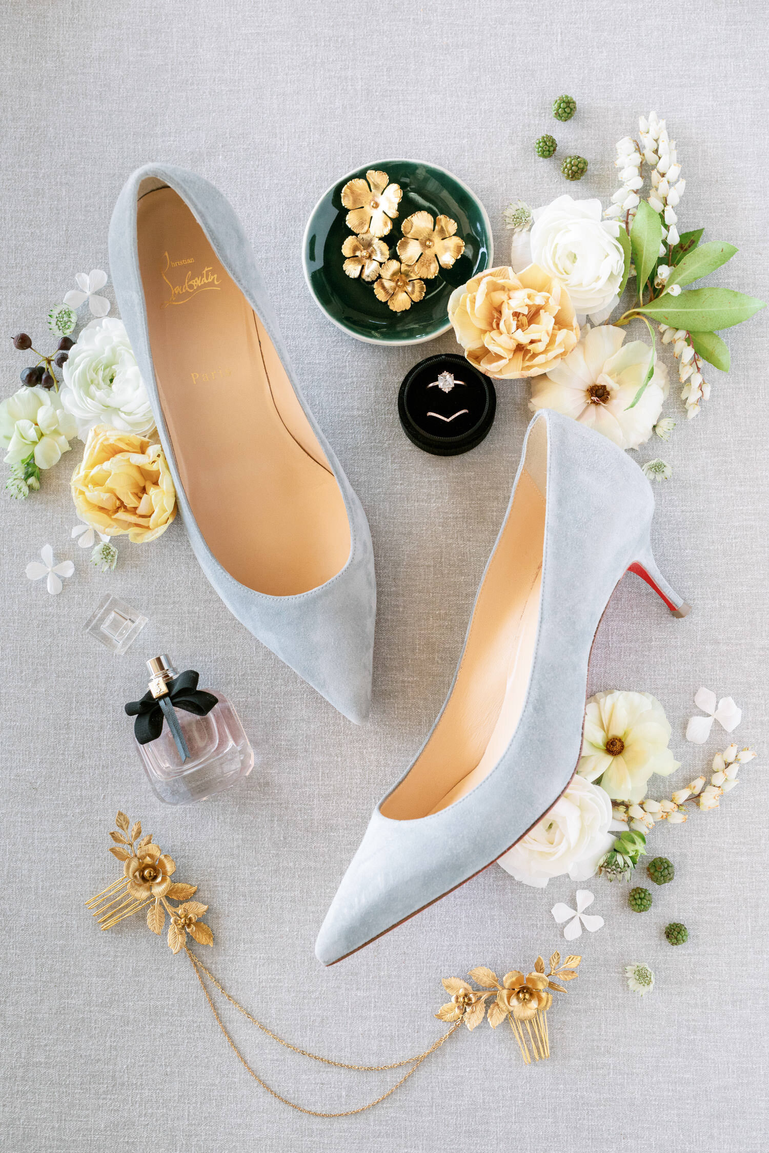 Wedding details including wedding rings, Christian Louboutin heels, perfume, and flowers