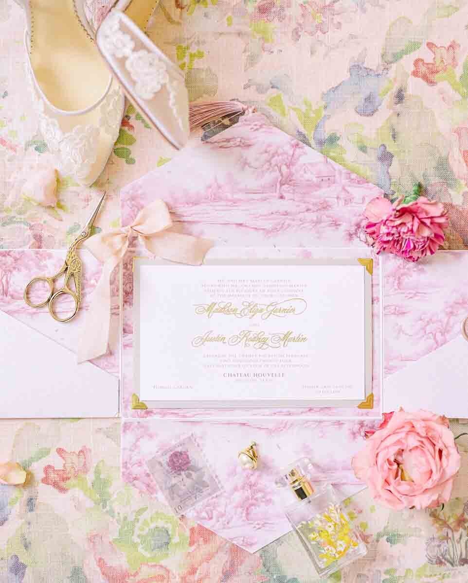 beautifully staged photo of wedding invitation and accessories