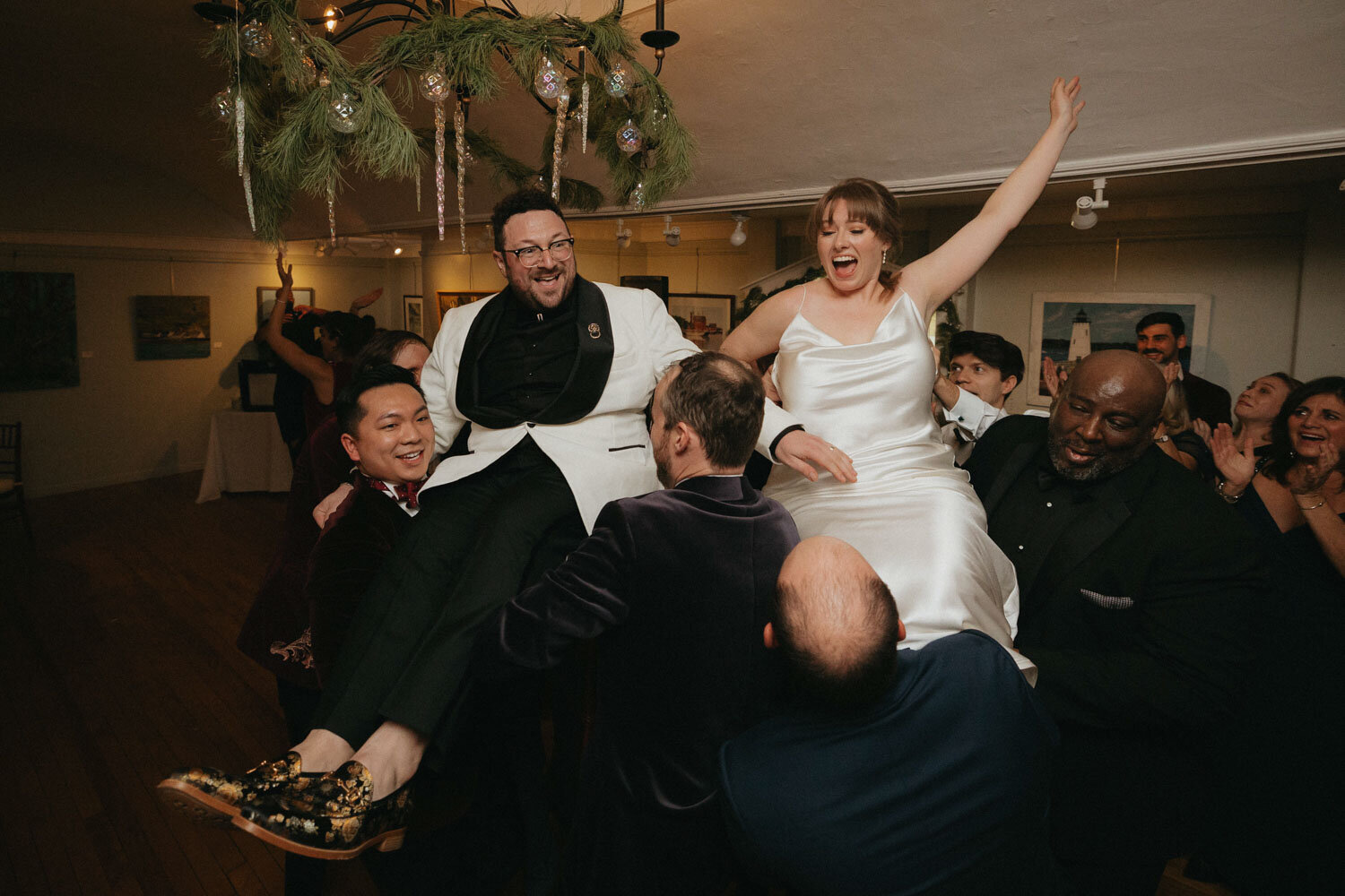 Bride and groom lifted by friends at a wedding reception