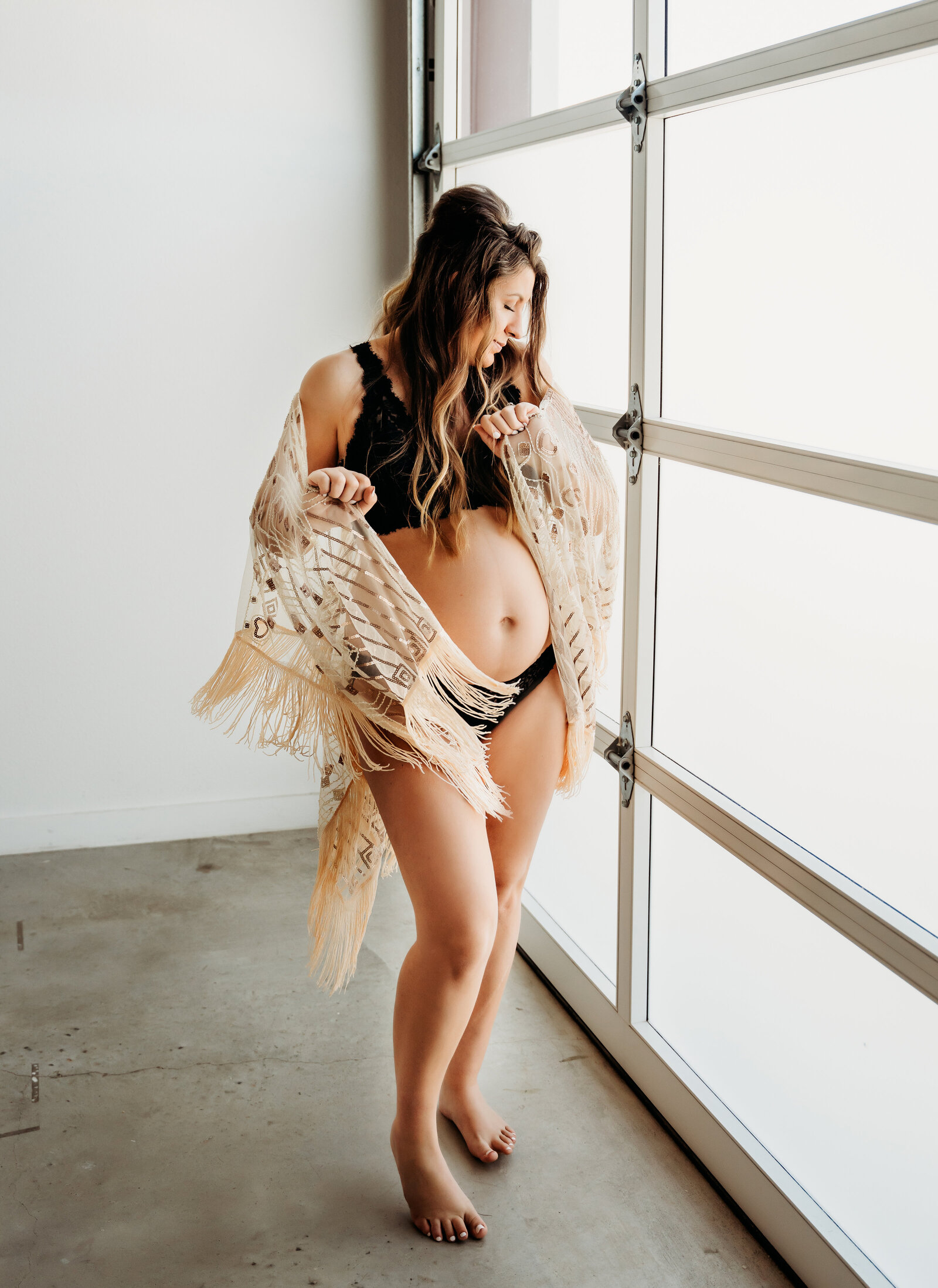 Maternity Photographer, an expectant mother wears bikini and holds shawl as she dances and smiles