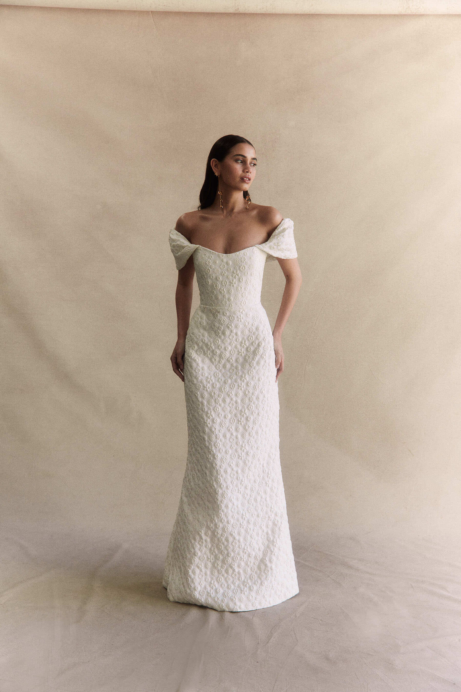 bride wearing white textured wedding dress with long sleeves