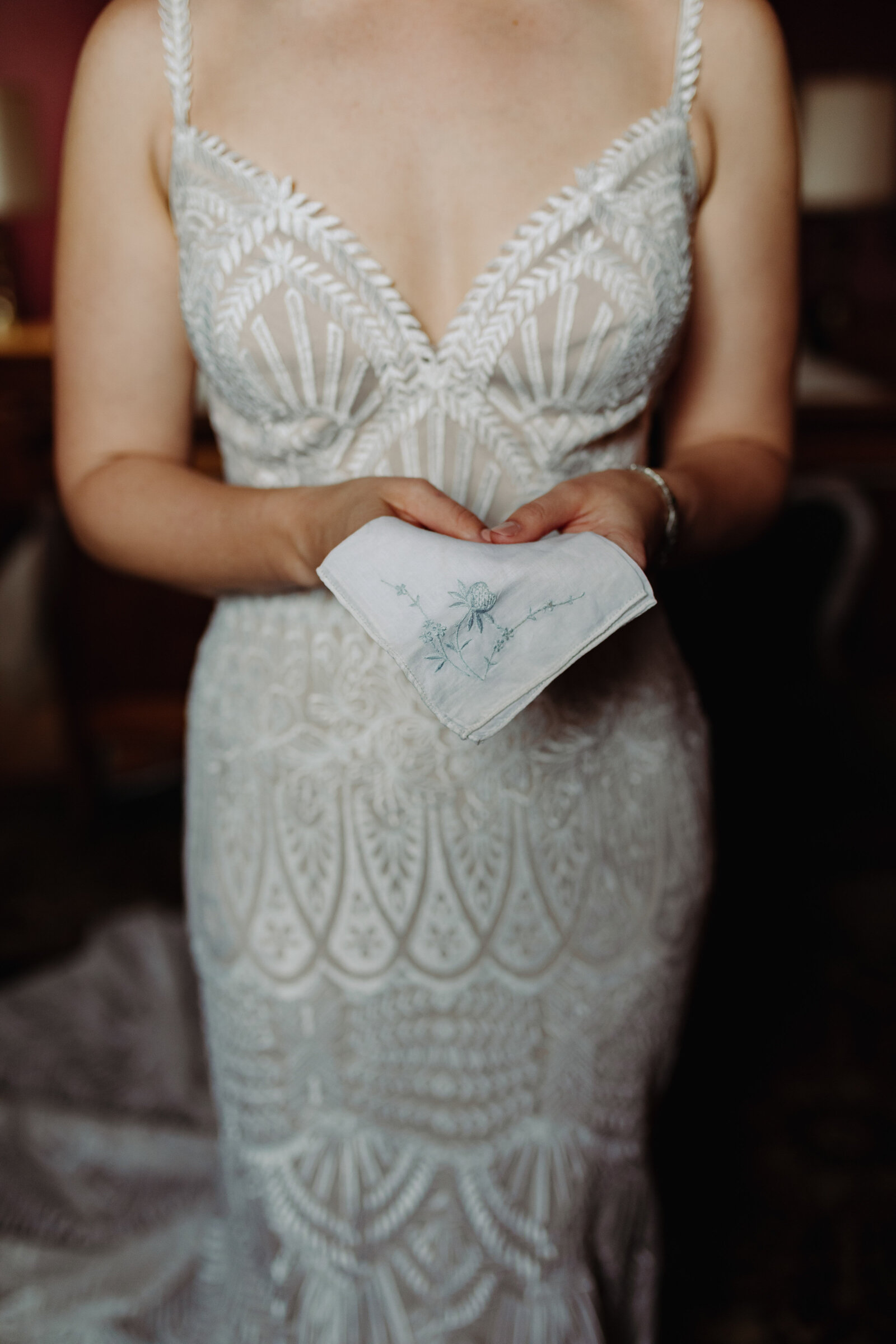 A bride in a vintage wedding dress holds out a handkerchief