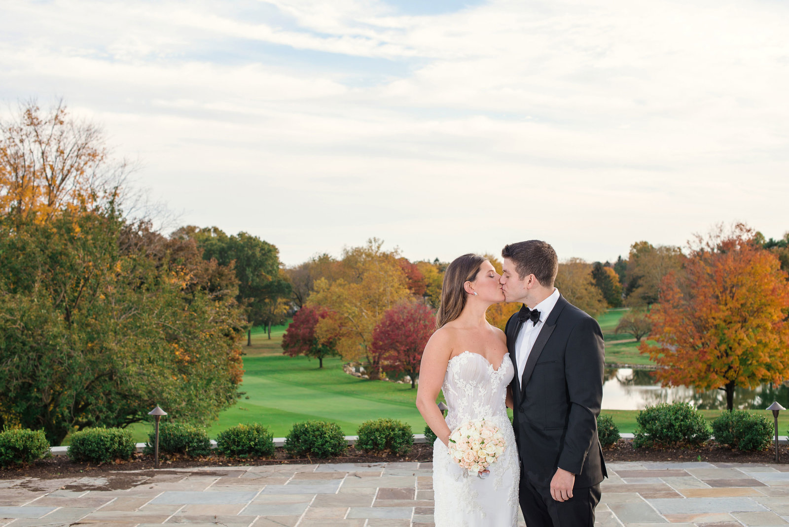 bride and groom kissing outside Glen Head Country Club
