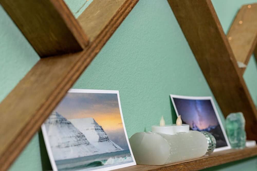 A serene display of calming decor in a Colorado massage room, featuring soft candlelight and nature-inspired images, creating a peaceful wellness atmosphere.