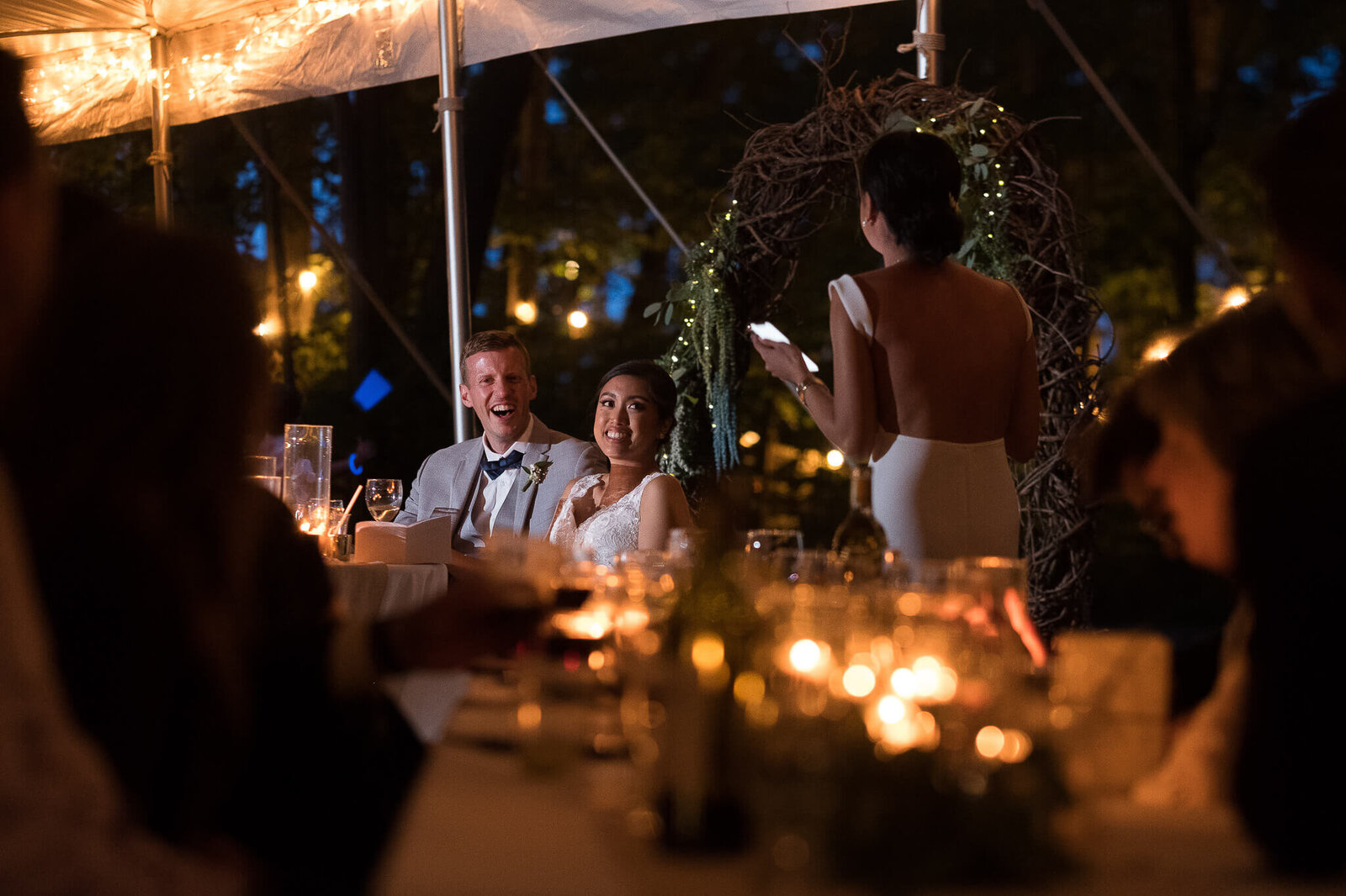 Bride and groom laughing during Maid of Honour speech.