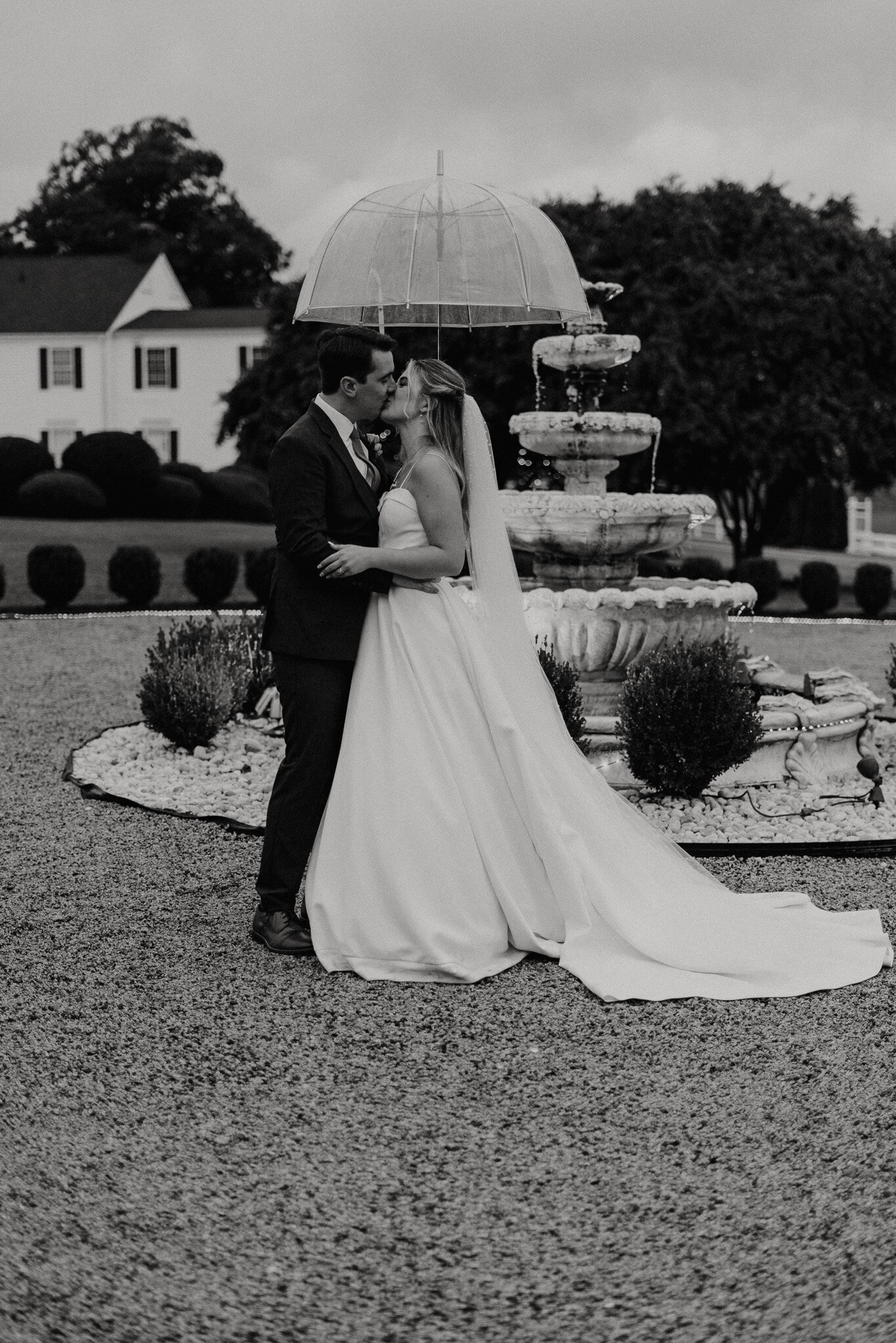 Bride and groom kissing under umbrella