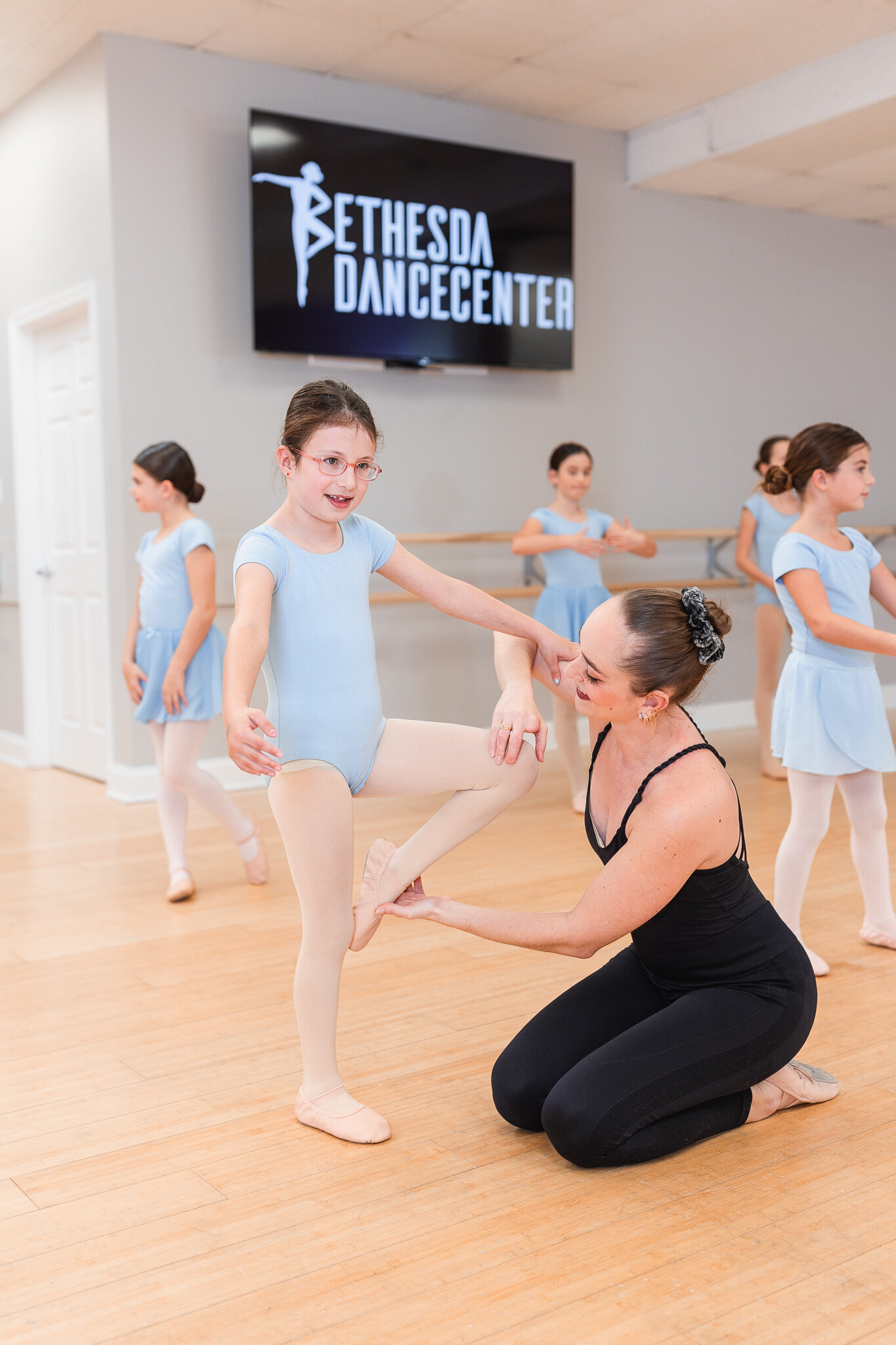 a dance teacher offers corrections to their student