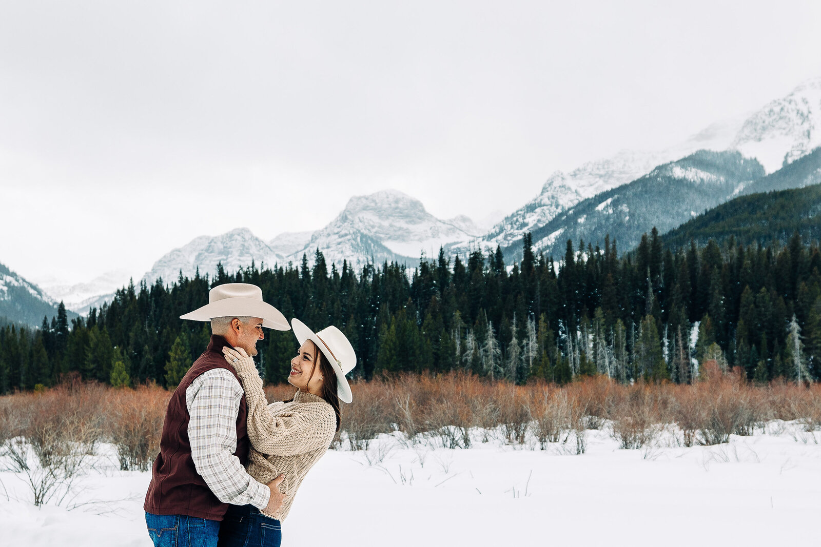 Embrace the magic of winter romance with our enchanting snowy mountain engagement photos. Amidst the pristine beauty of snow-capped peaks, let our images capture the warmth of your love against the cool, serene backdrop of nature's wonderland. Celebrate your journey together amidst the tranquility of snowy vistas, creating timeless memories to cherish forever