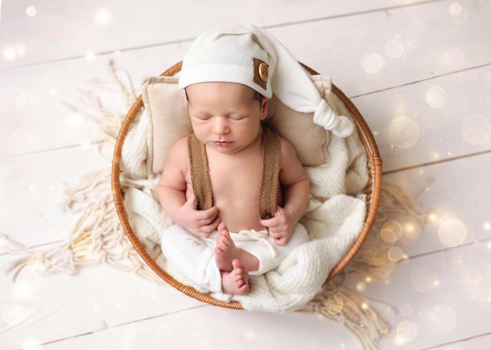 baby boy with cute outfit in a basket and neutral colors at Edmonton studio.