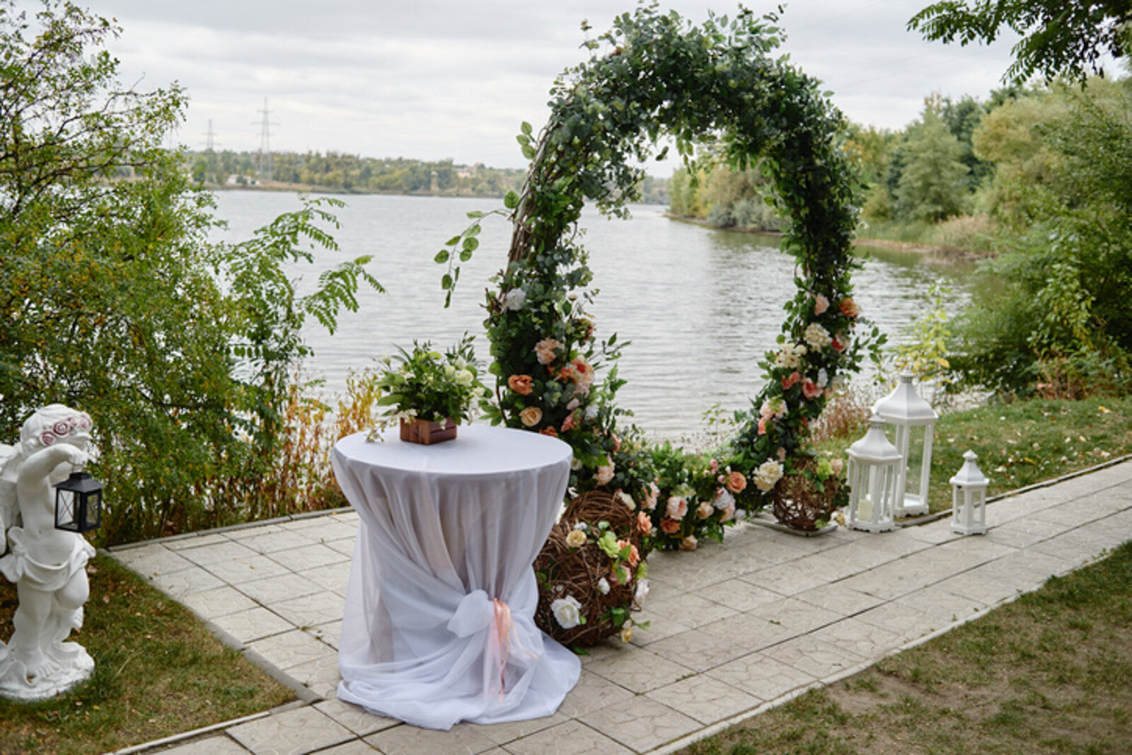 Wedding reception area with floral round backdrop beside the lake