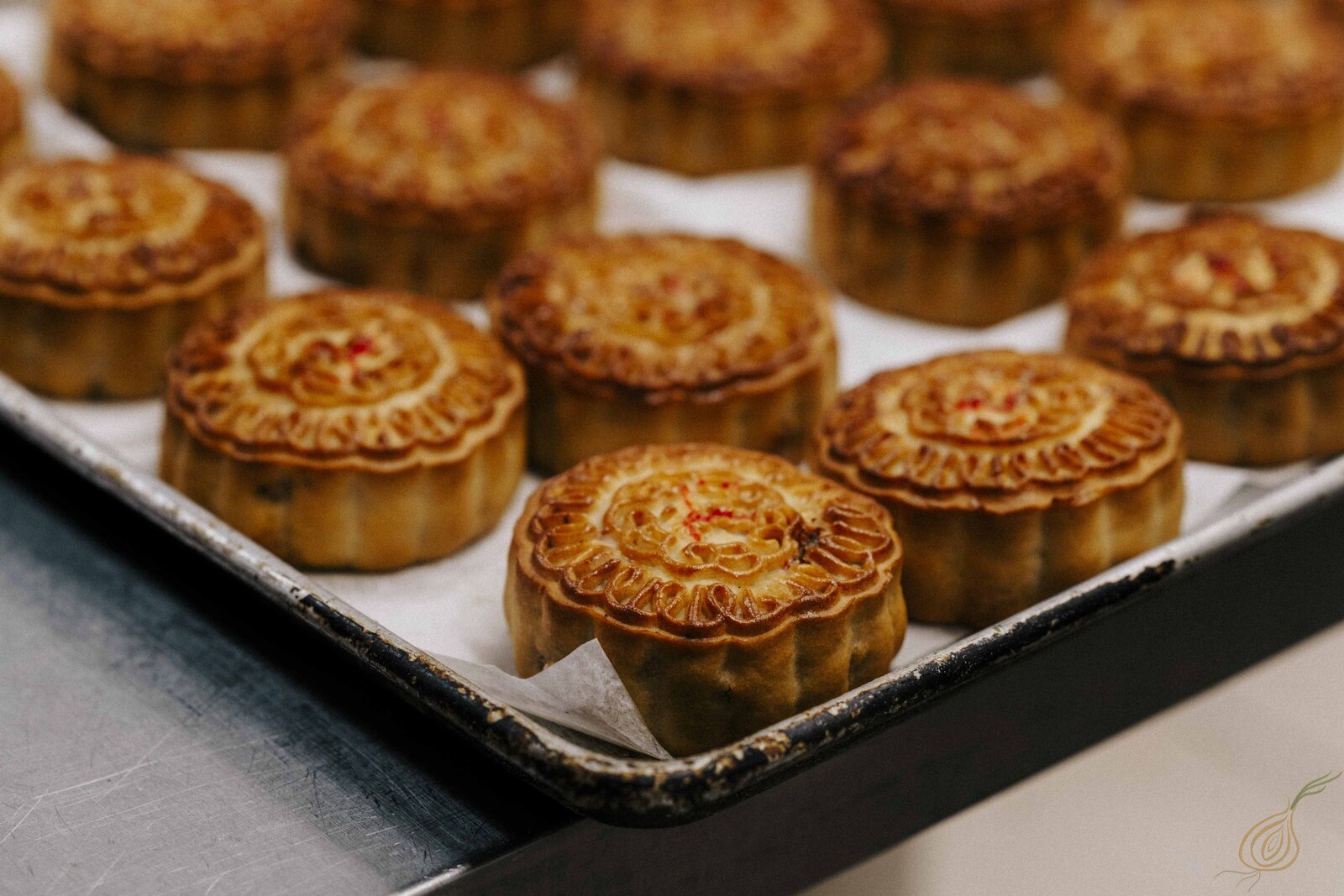 A tray of beautifully arranged moon cakes displayed elegantly on a wooden table, inviting and festive in appearance.